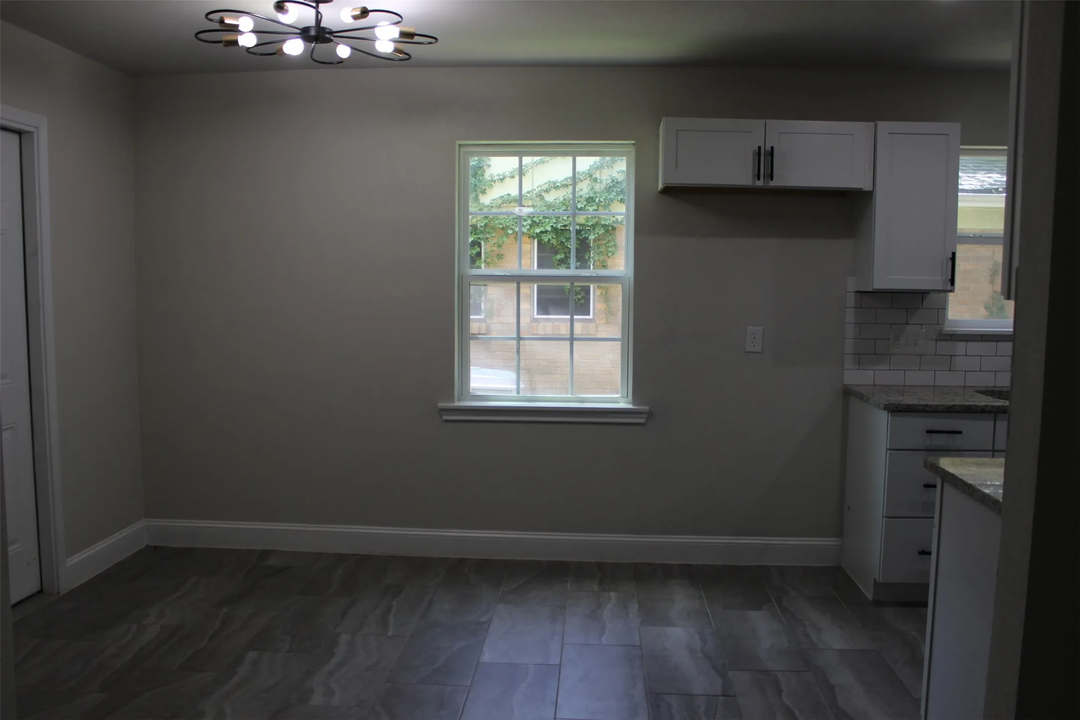 Contemporary ceiling light fixture illuminating an interior space with wood-finish flooring