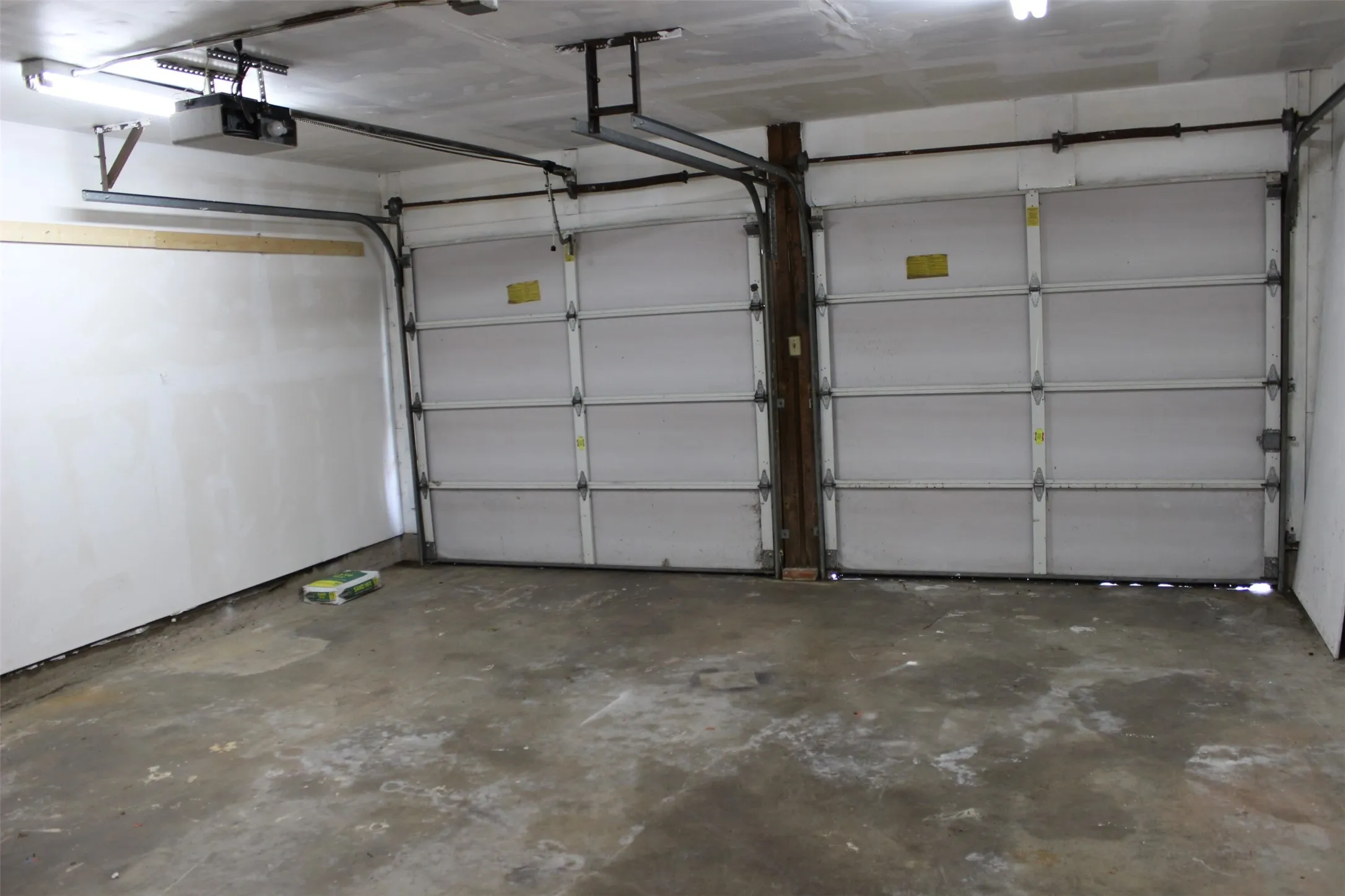 Two white panel garage doors with automatic openers