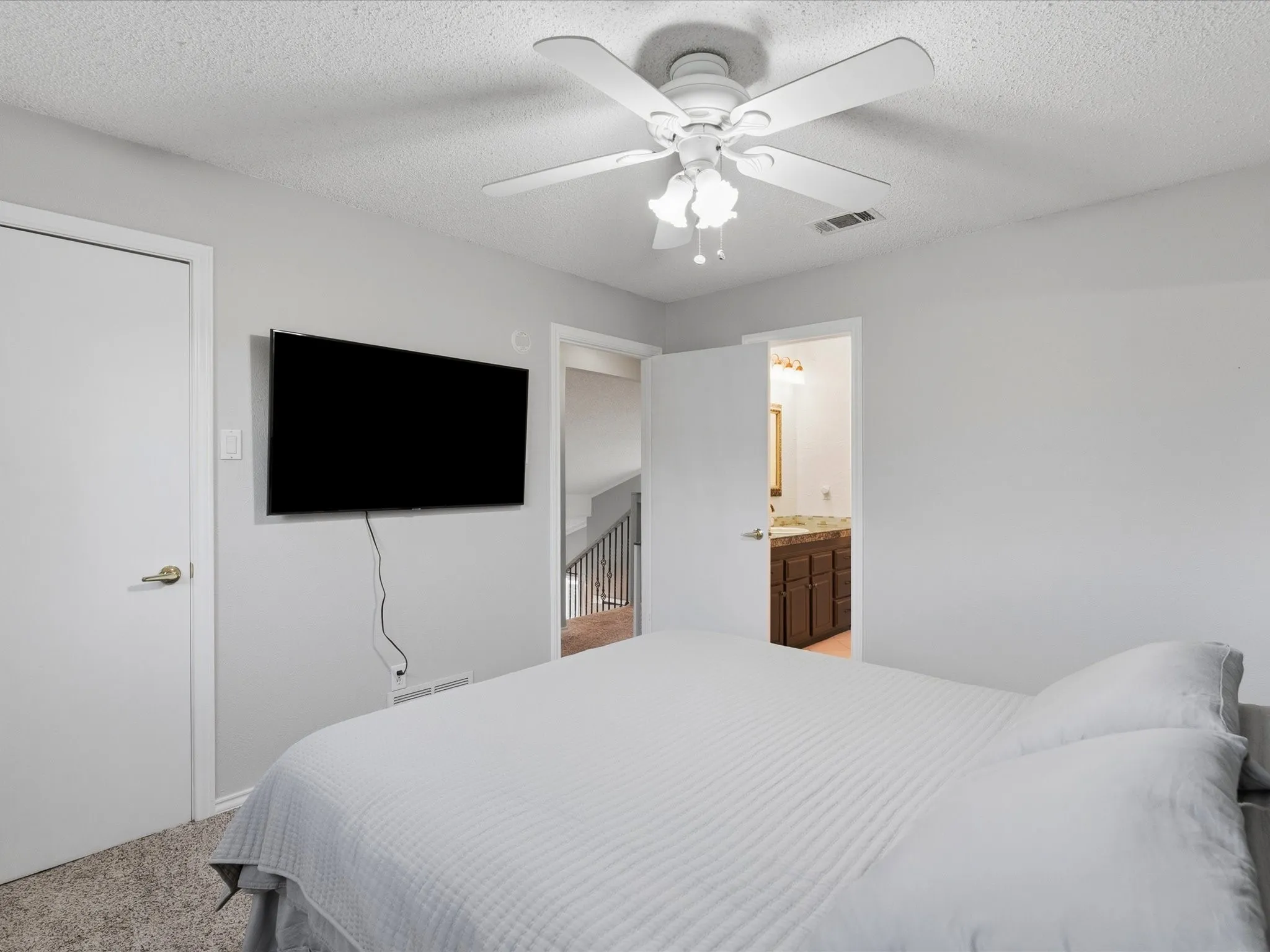 Carpeted room featuring a ceiling fan with light fixture and light gray walls