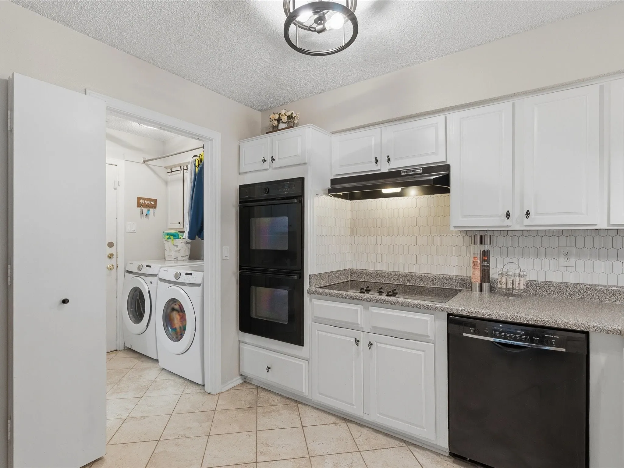 Modern kitchen featuring white cabinetry, a built-in double oven, and a cooktop