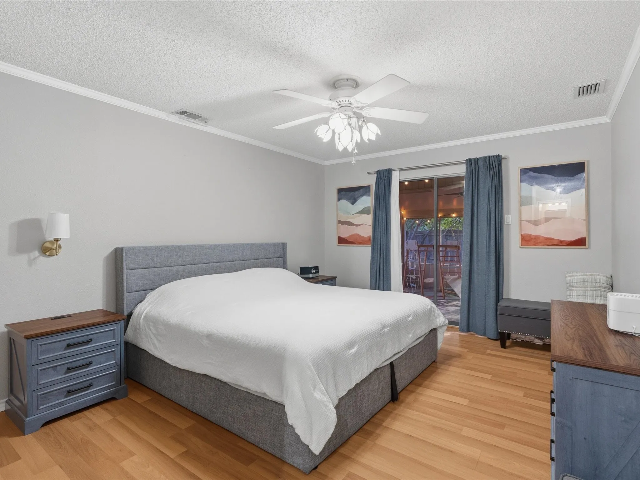 Hardwood-style flooring throughout, crowned ceiling, and a ceiling fan with integrated lighting