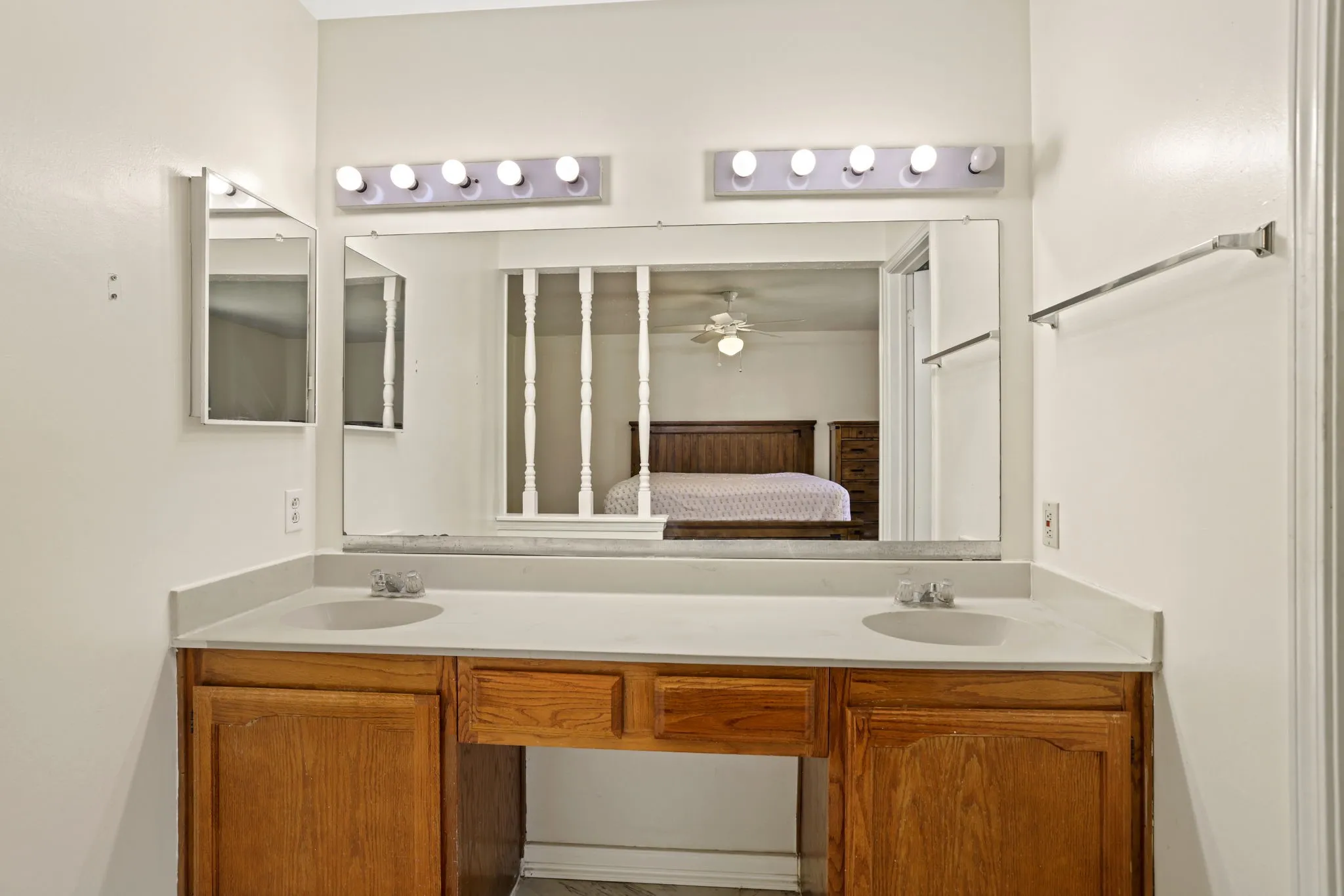 Double vanity with a light-toned countertop and wood-finish cabinetry