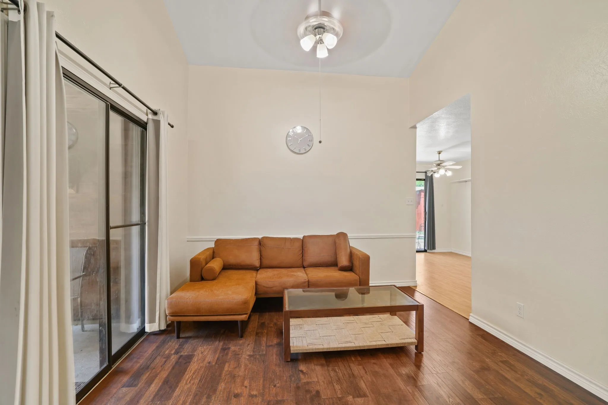 Spacious interior featuring wood-finish flooring, vaulted ceilings, and a ceiling fan with integrated​​‌​​​​‌​​‌‌​‌‌​​​‌‌​‌​‌​‌​​​‌​​ lighting
