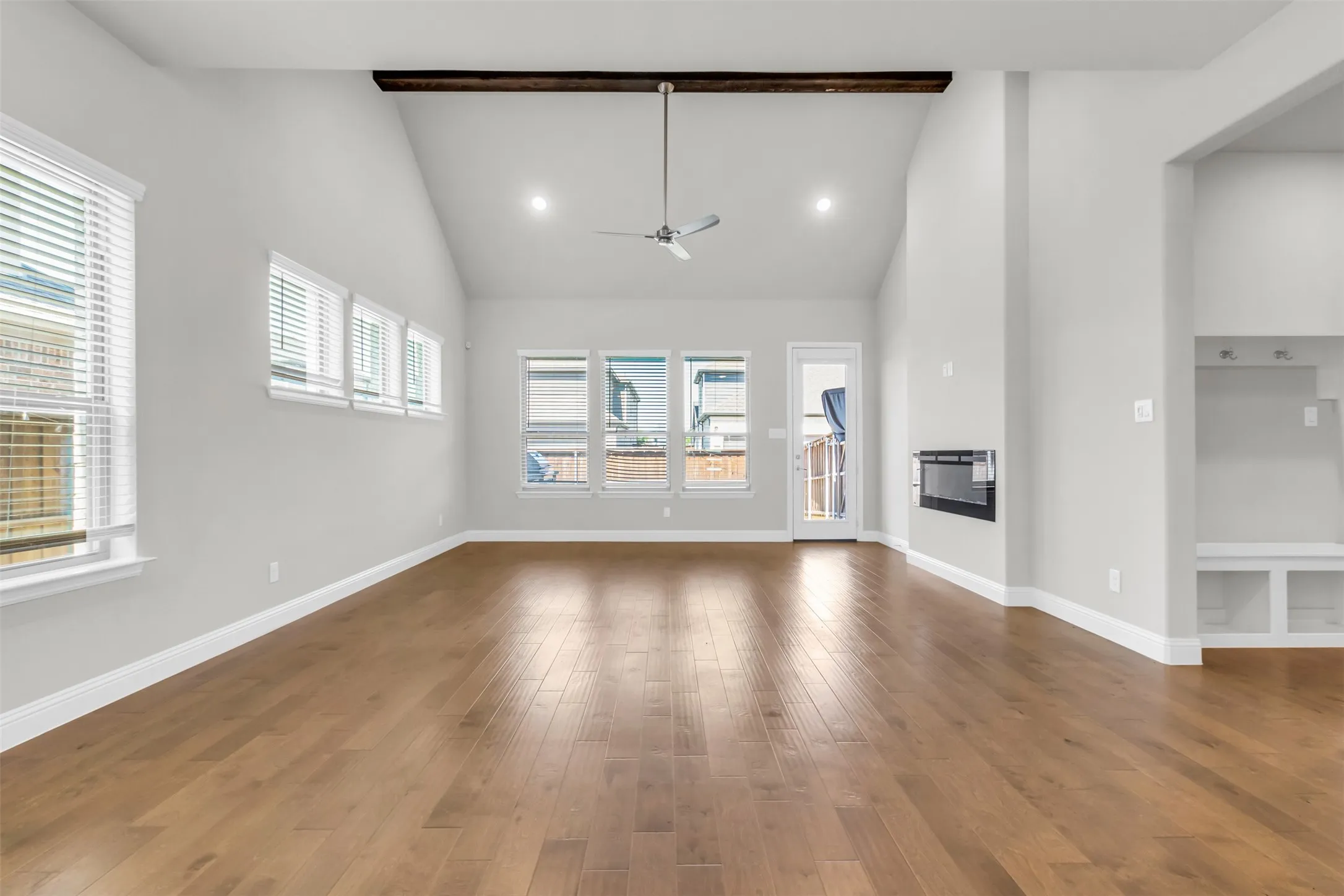 Unfurnished living room with high vaulted ceiling, ceiling fan, and wood-type flooring