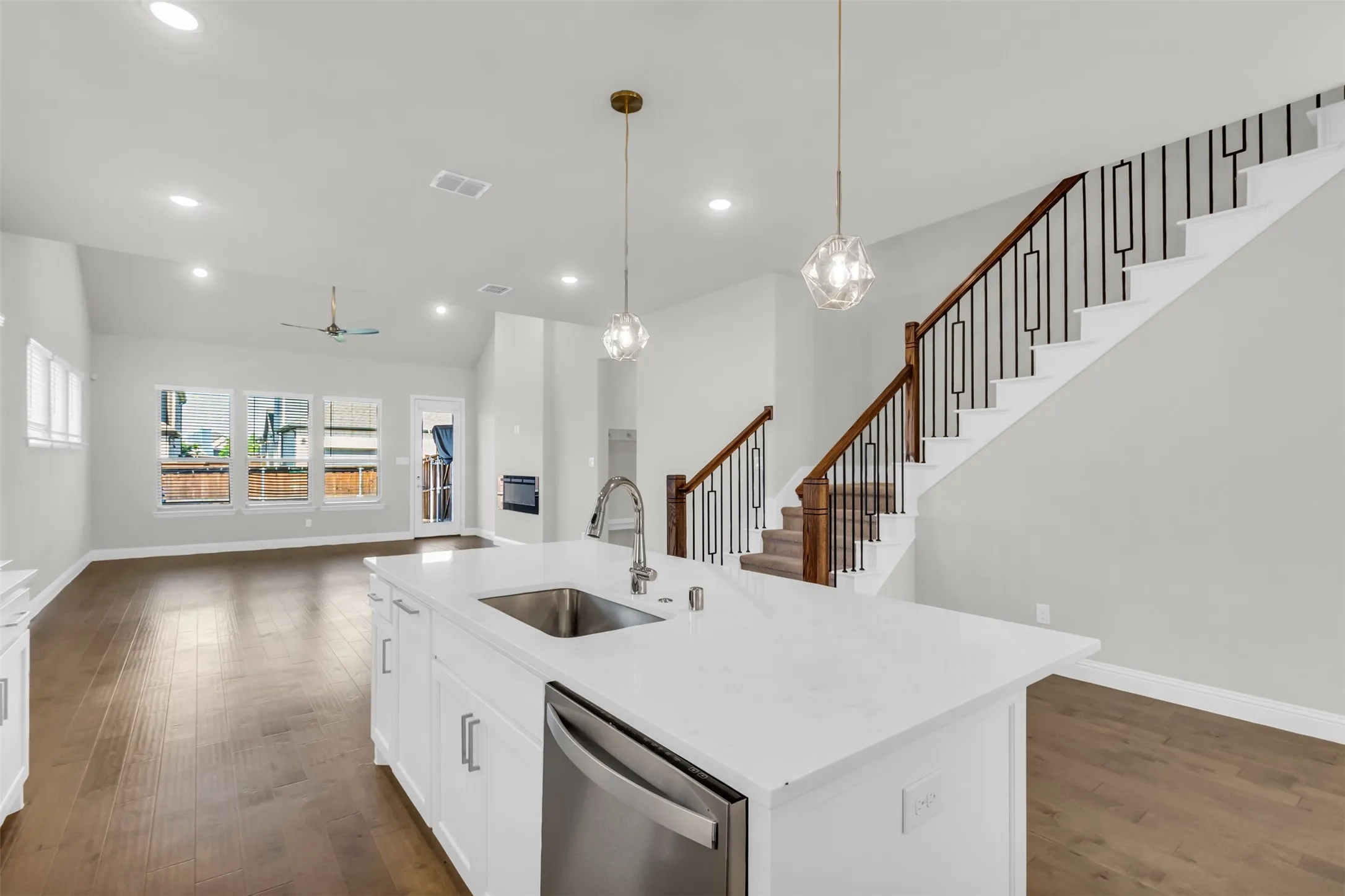 Kitchen with white cabinetry, pendant lighting, sink, dishwasher, and dark hardwood / wood-style floors