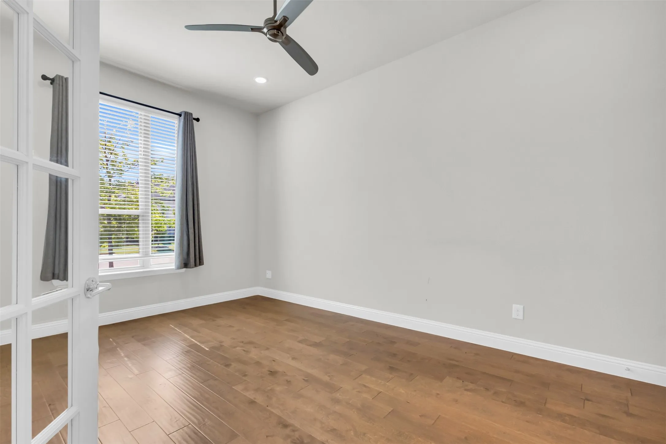 Empty room featuring ceiling fan and hardwood / wood-style flooring
