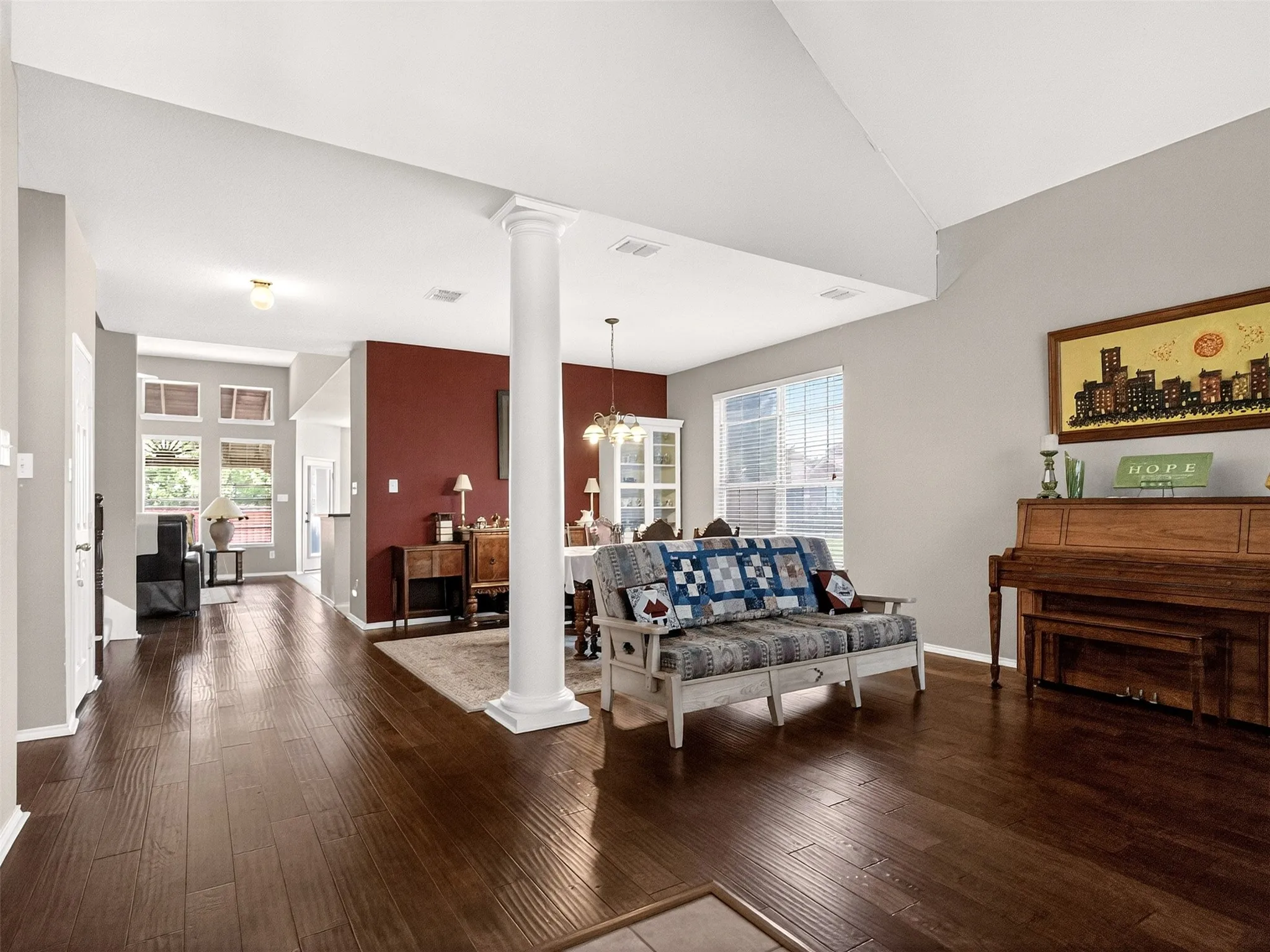 Spacious interior featuring wood-finish flooring, a decorative column, and painted accent walls