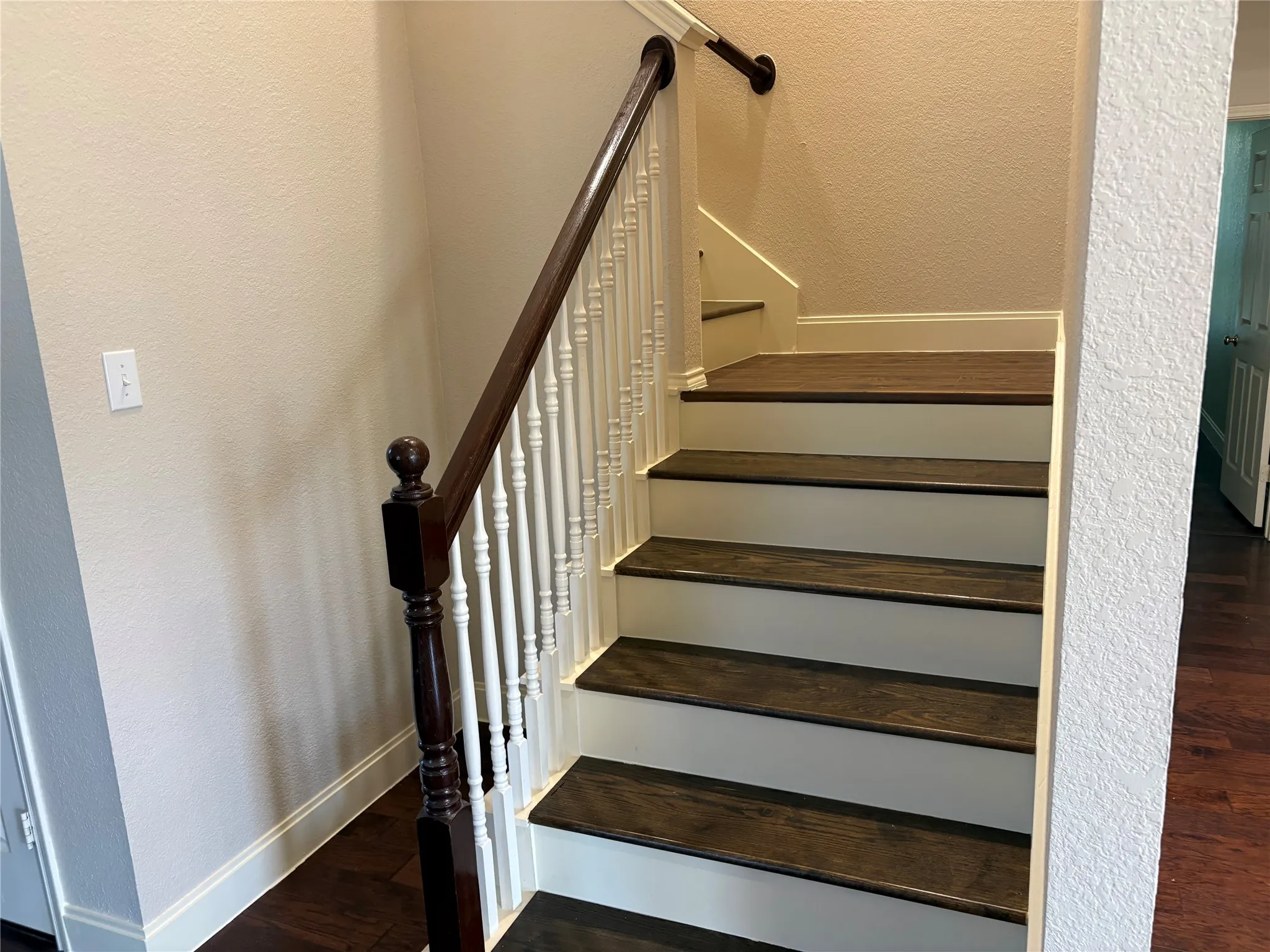Staircase featuring dark wood-finish treads and white risers