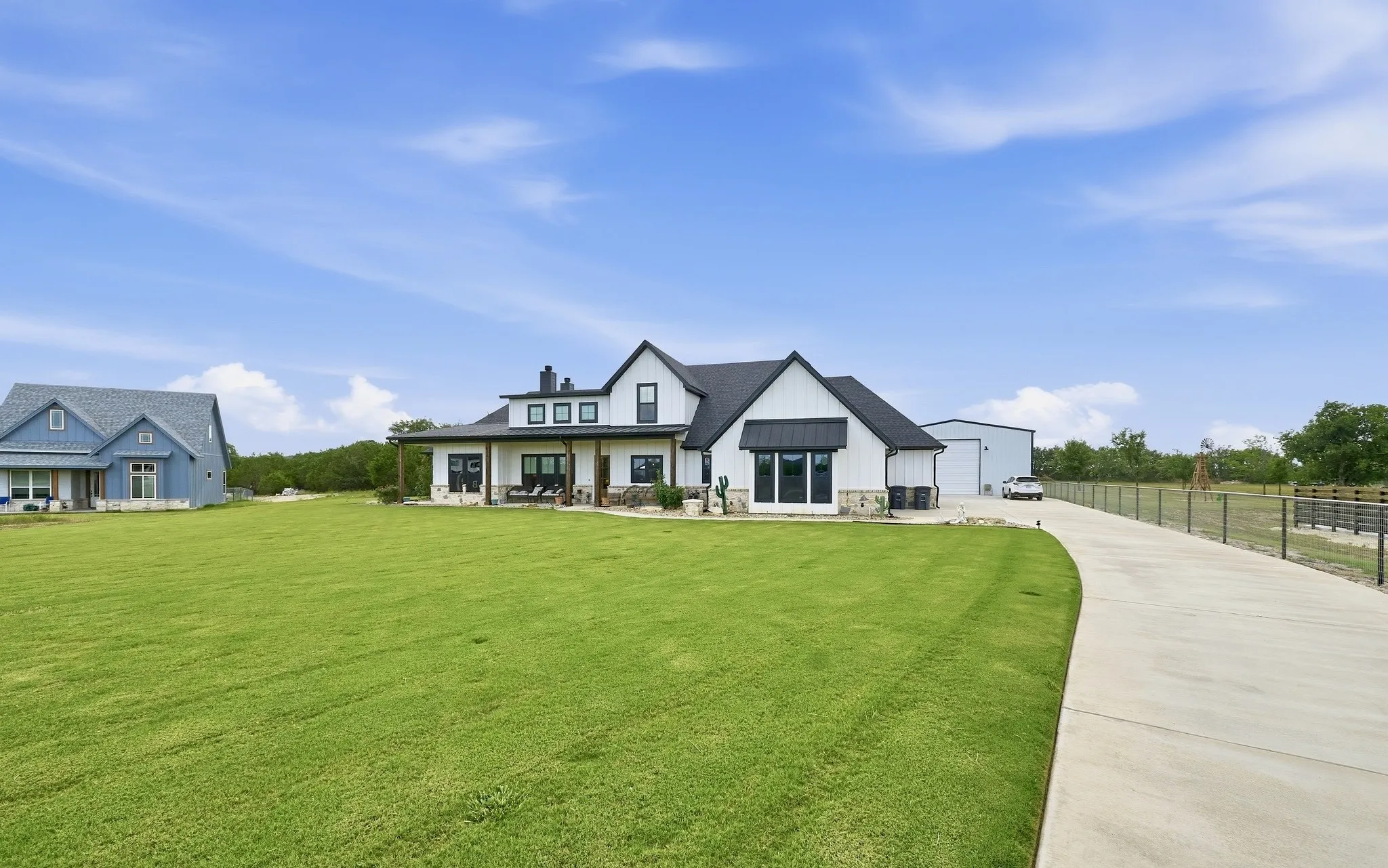 Modern farmhouse with white board and batten siding, black trim, and a covered porch