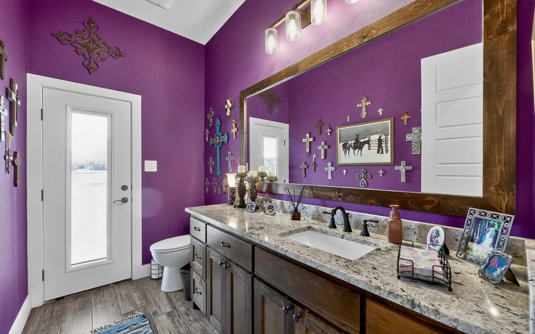 Bathroom featuring a dual vanity with a light-colored speckled countertop and dark wood-finish cabinetry