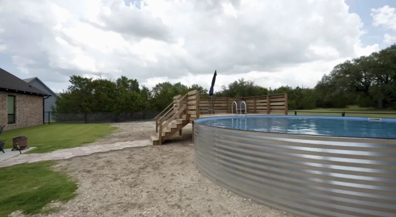 Above-ground pool with metal siding and a wooden deck