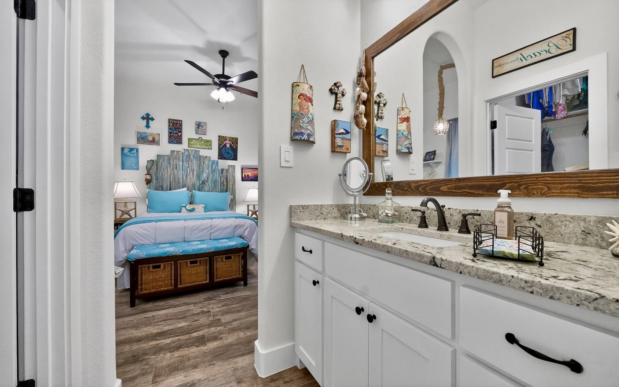 Bathroom vanity with granite countertop and white cabinetry, featuring a single sink and bronze-finish faucet