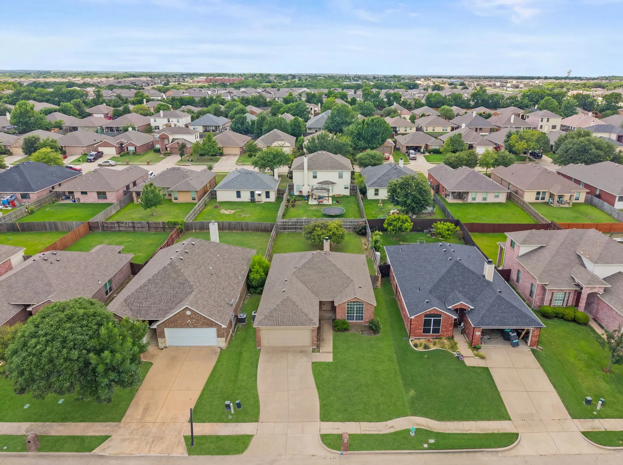 Residential neighborhood featuring single-story homes with shingle roofs and fenced backyards