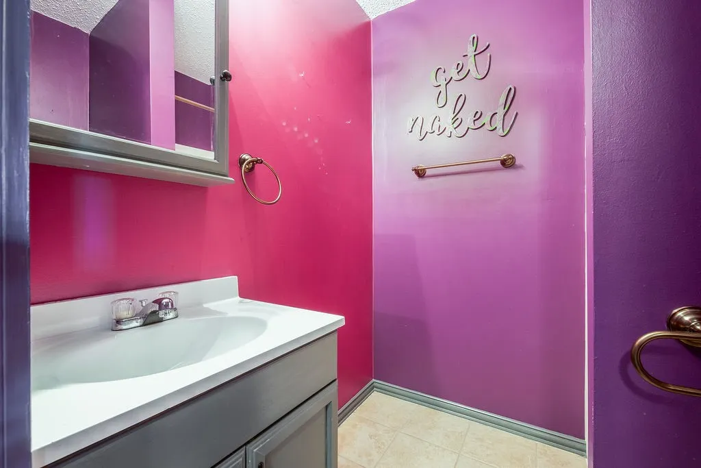 Bathroom vanity with an integrated sink, dual-handle faucet, and gray cabinetry