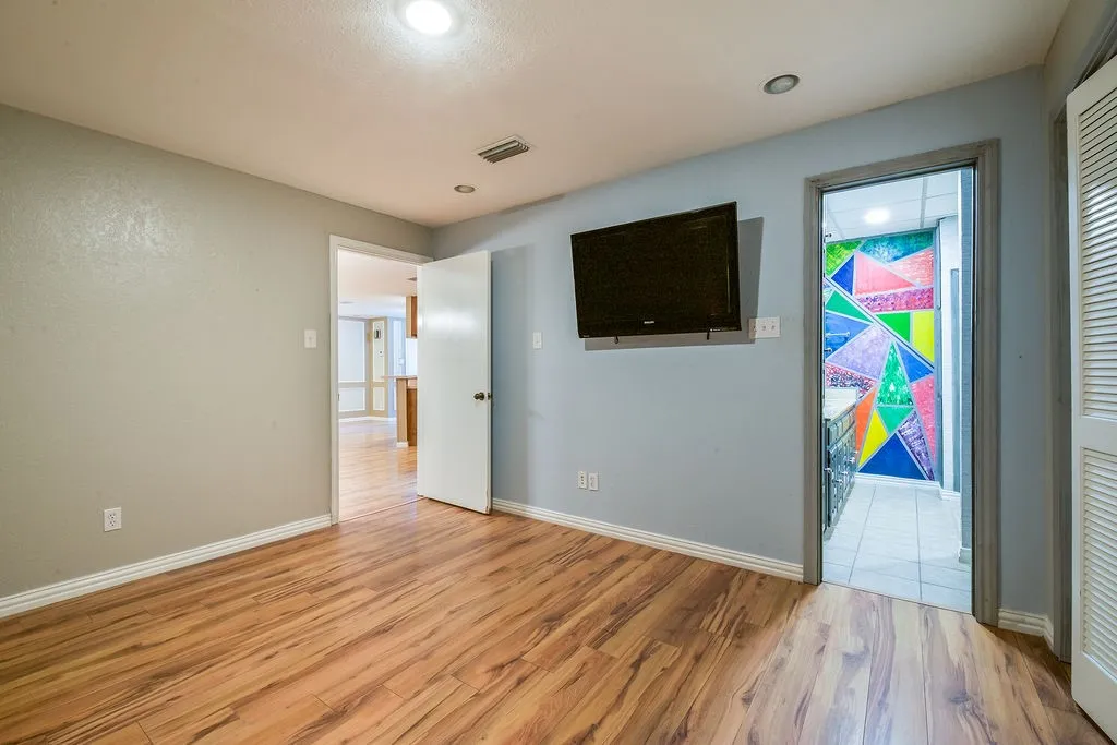 Wood-finish flooring throughout, complemented by a light gray wall color