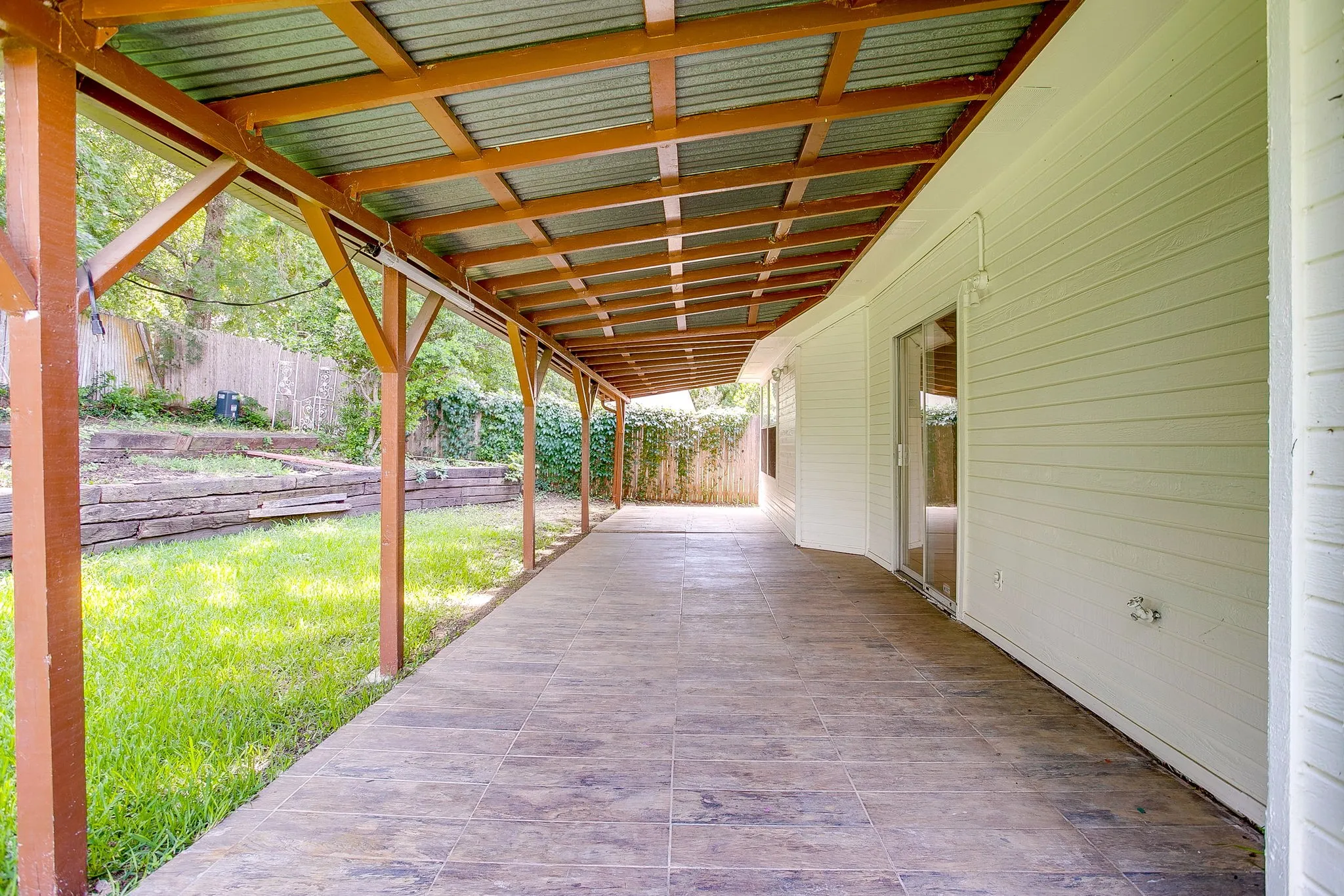 Exterior expansive patio with wood-beam ceiling.