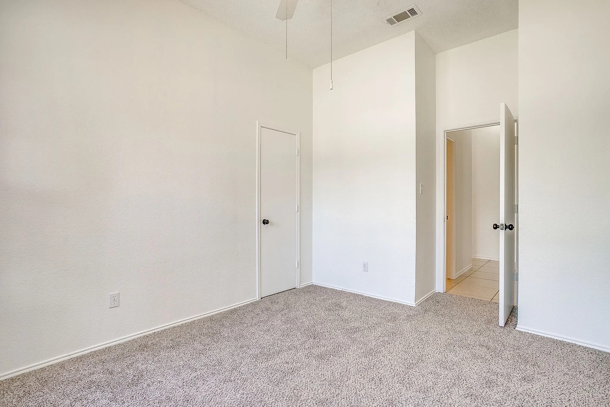 Bedroom featuring natural toned carpet.
