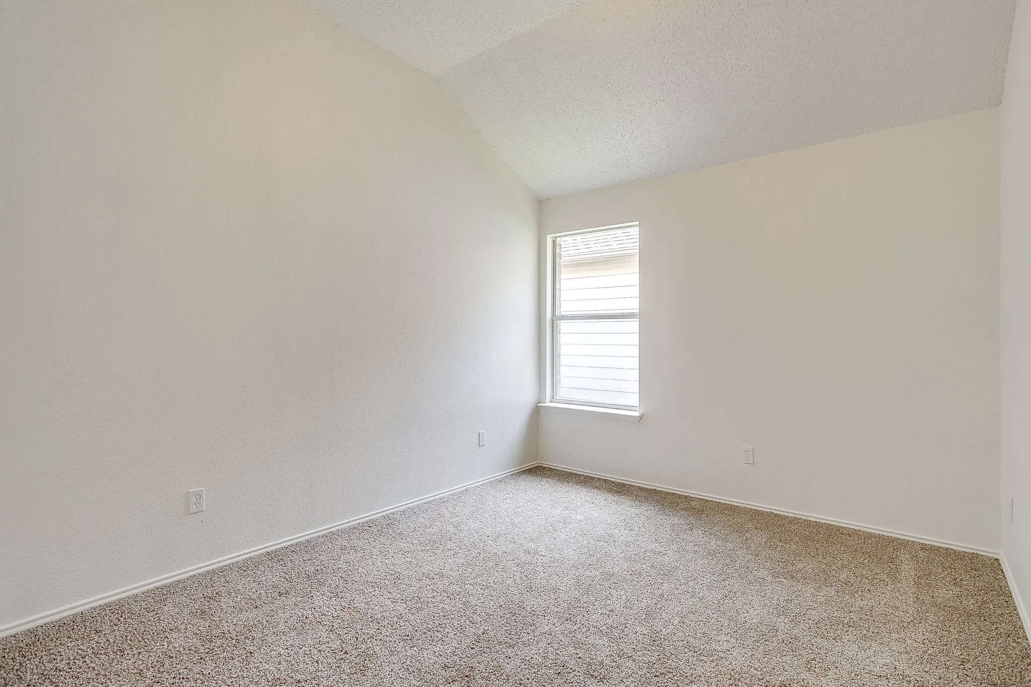 Bedroom with corner window providing natural light.
