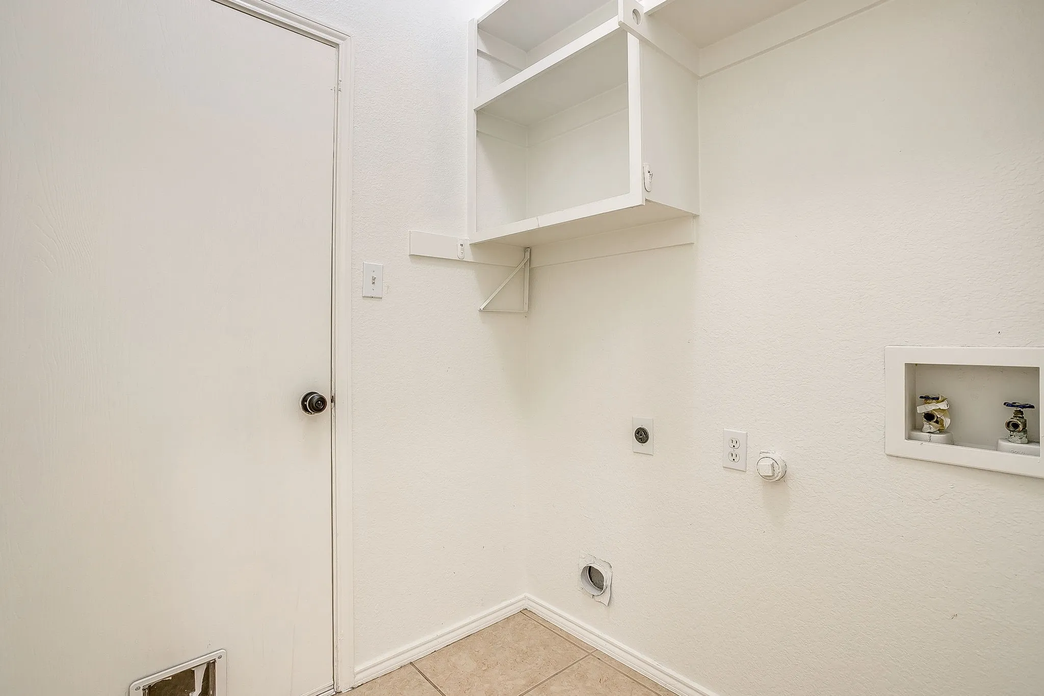 Laundry room featuring space for side by side washer and dryer and built in shelves.