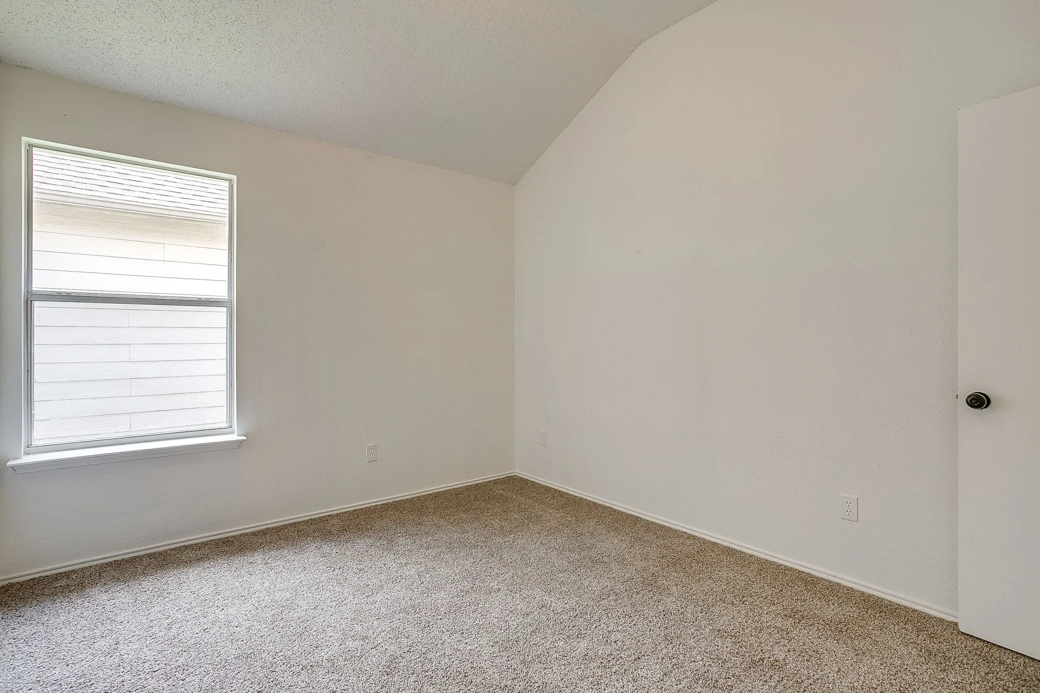 Bedroom featuring a high sloped ceiling.