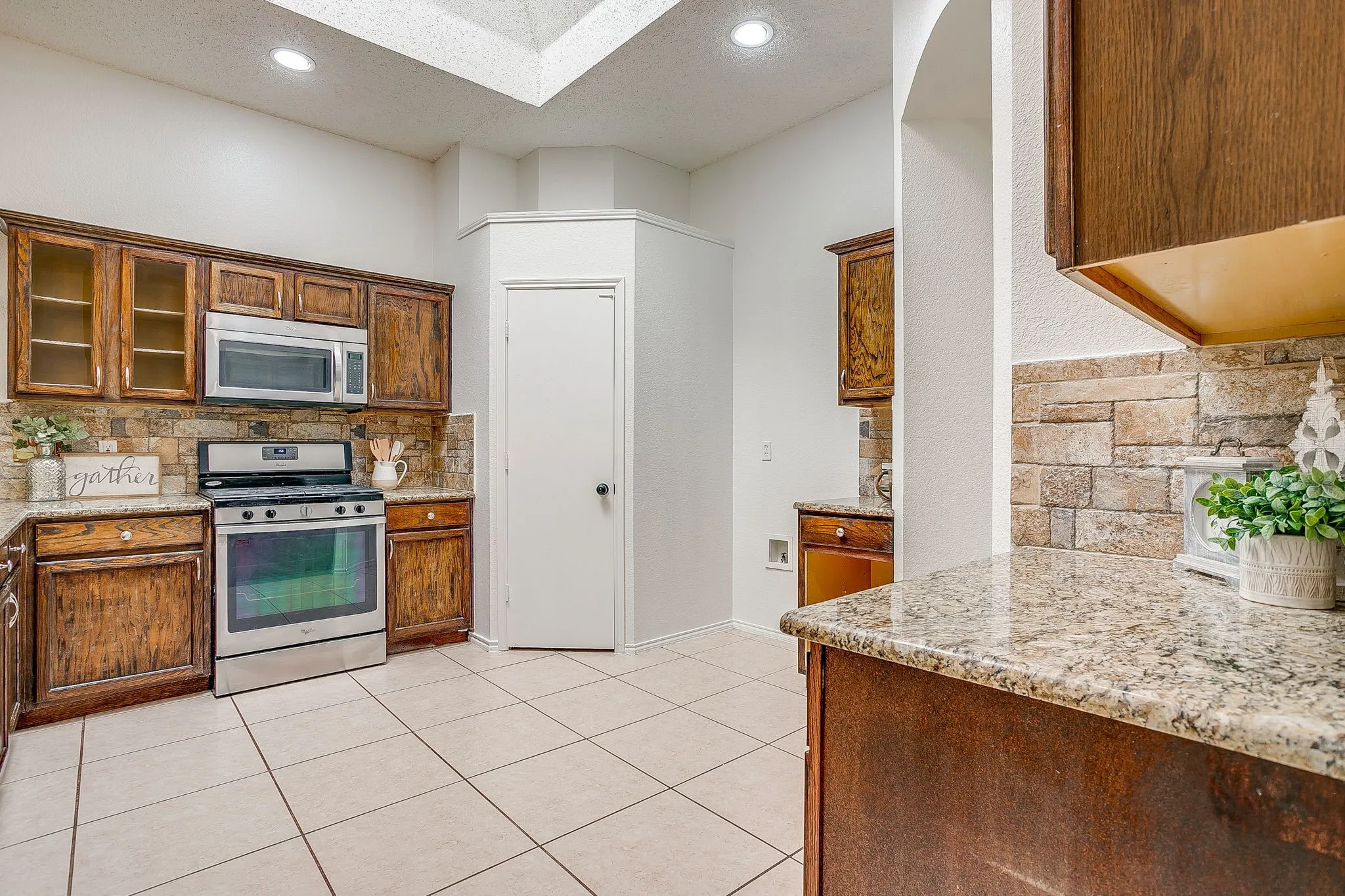 Kitchen featuring granite countertops and stacked stone backsplash.