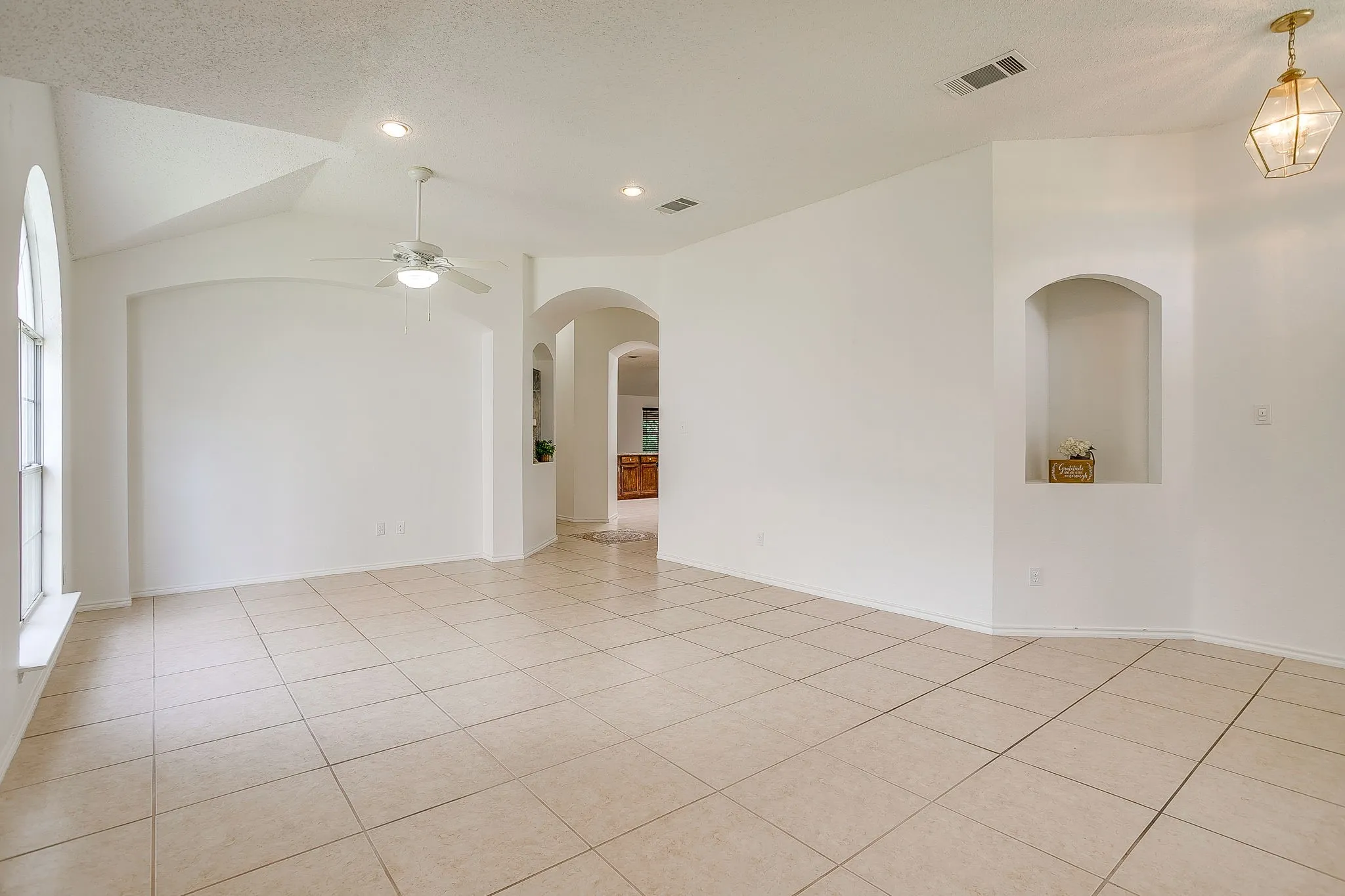 This great room displays arched architectural doorway and recessed niche.