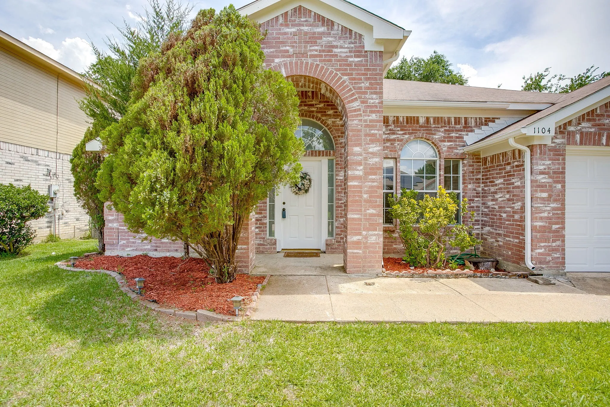 The exterior entrance featuring an elegant arched entry porch and transom window.