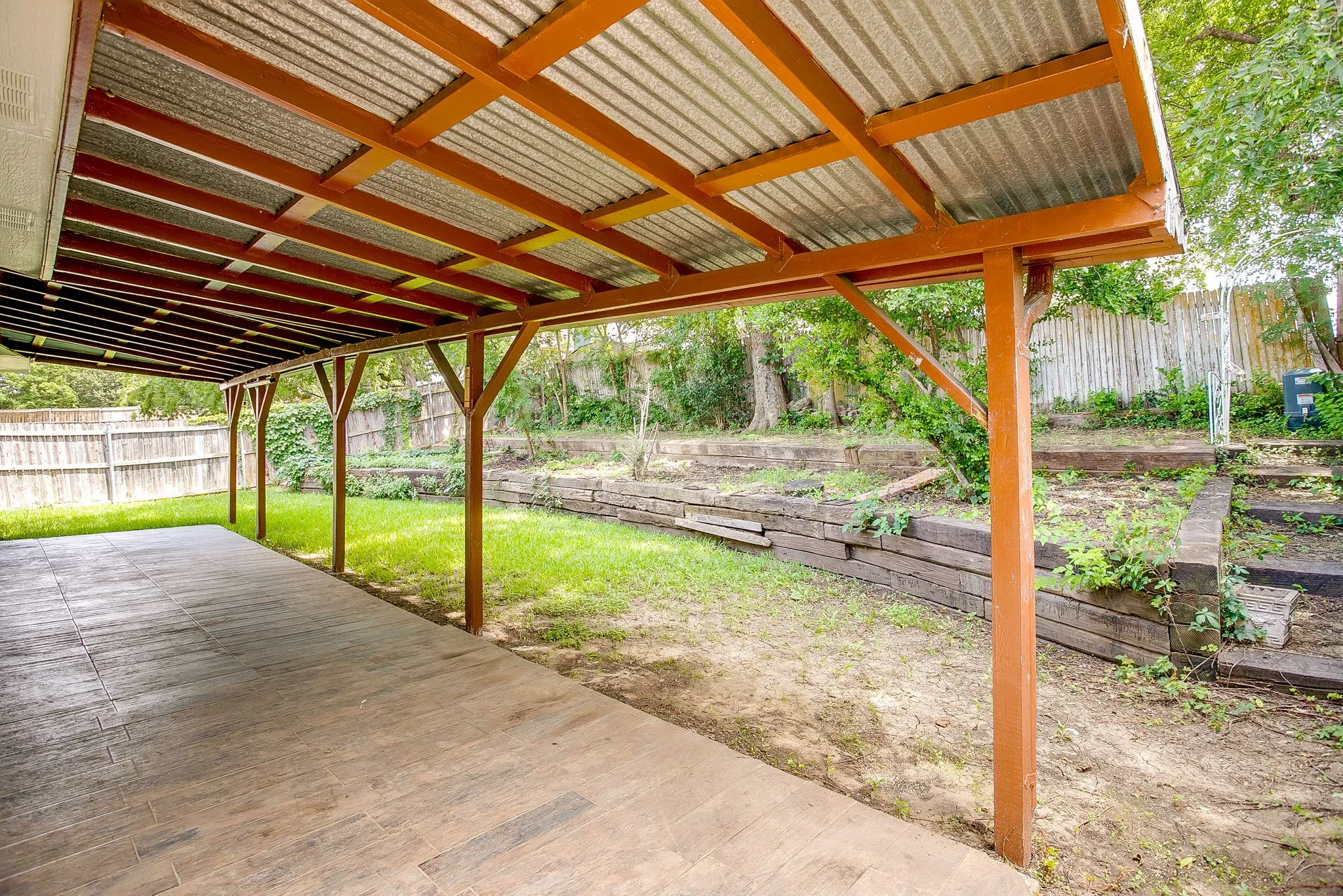 Covered patio overlooking the fenced back yard.