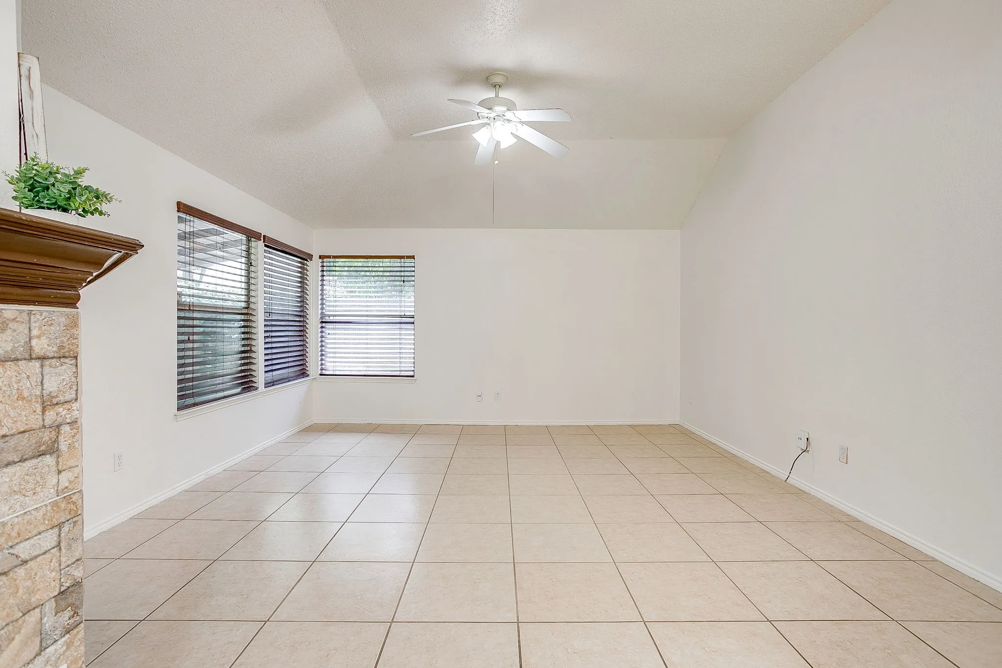Second living room situated off the dining area and kitchen, featuring three windows to allow for natural light.