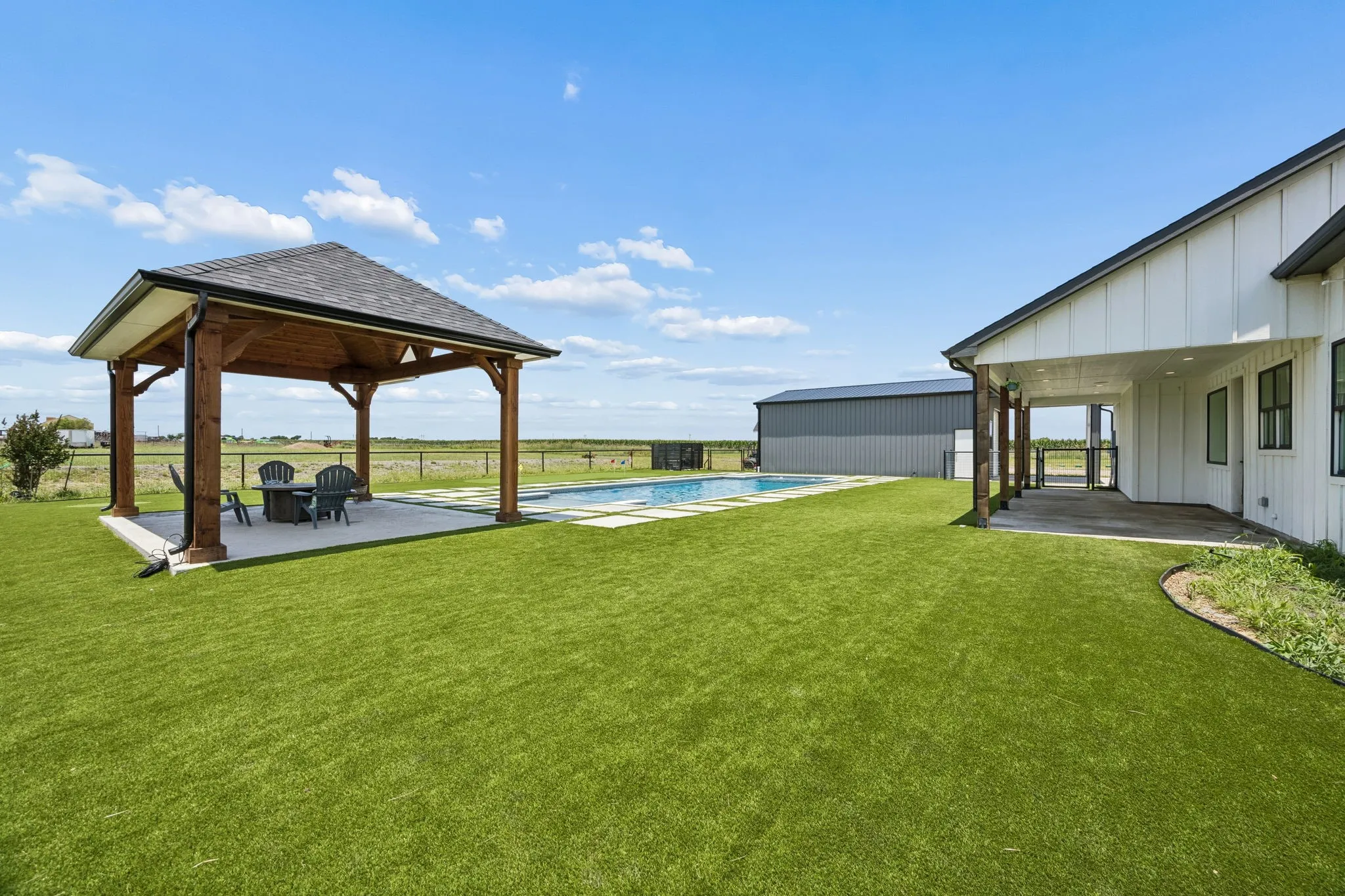 A custom-built, open-air pavilion with a solid roof anchors the backyard