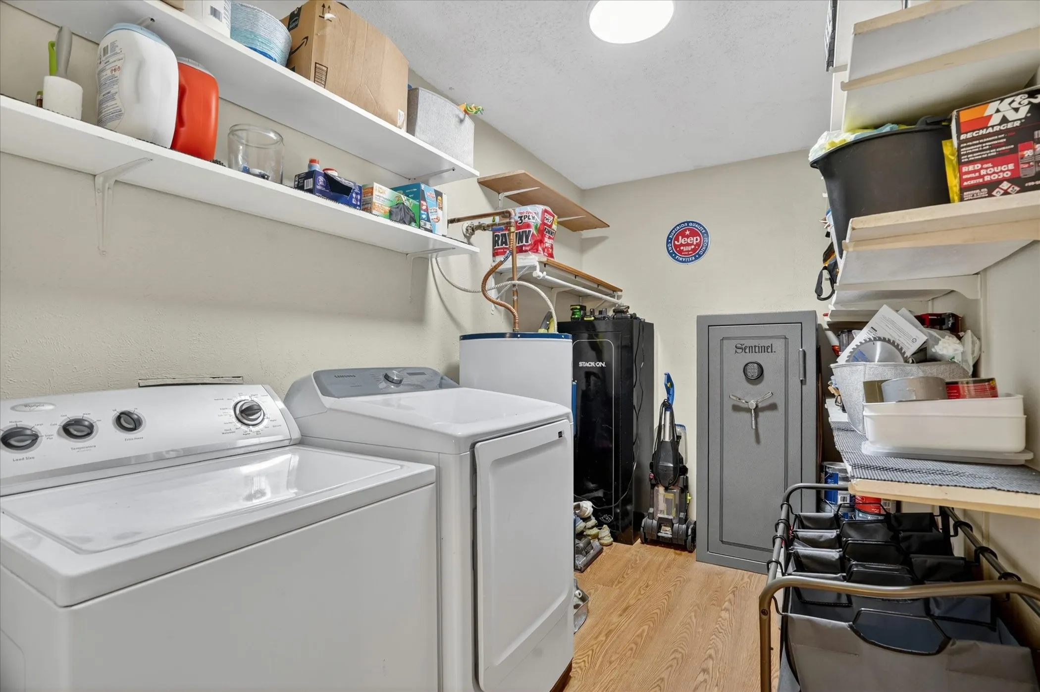 Utility room featuring wood-finish flooring, light neutral wall paint, and white shelving for storage