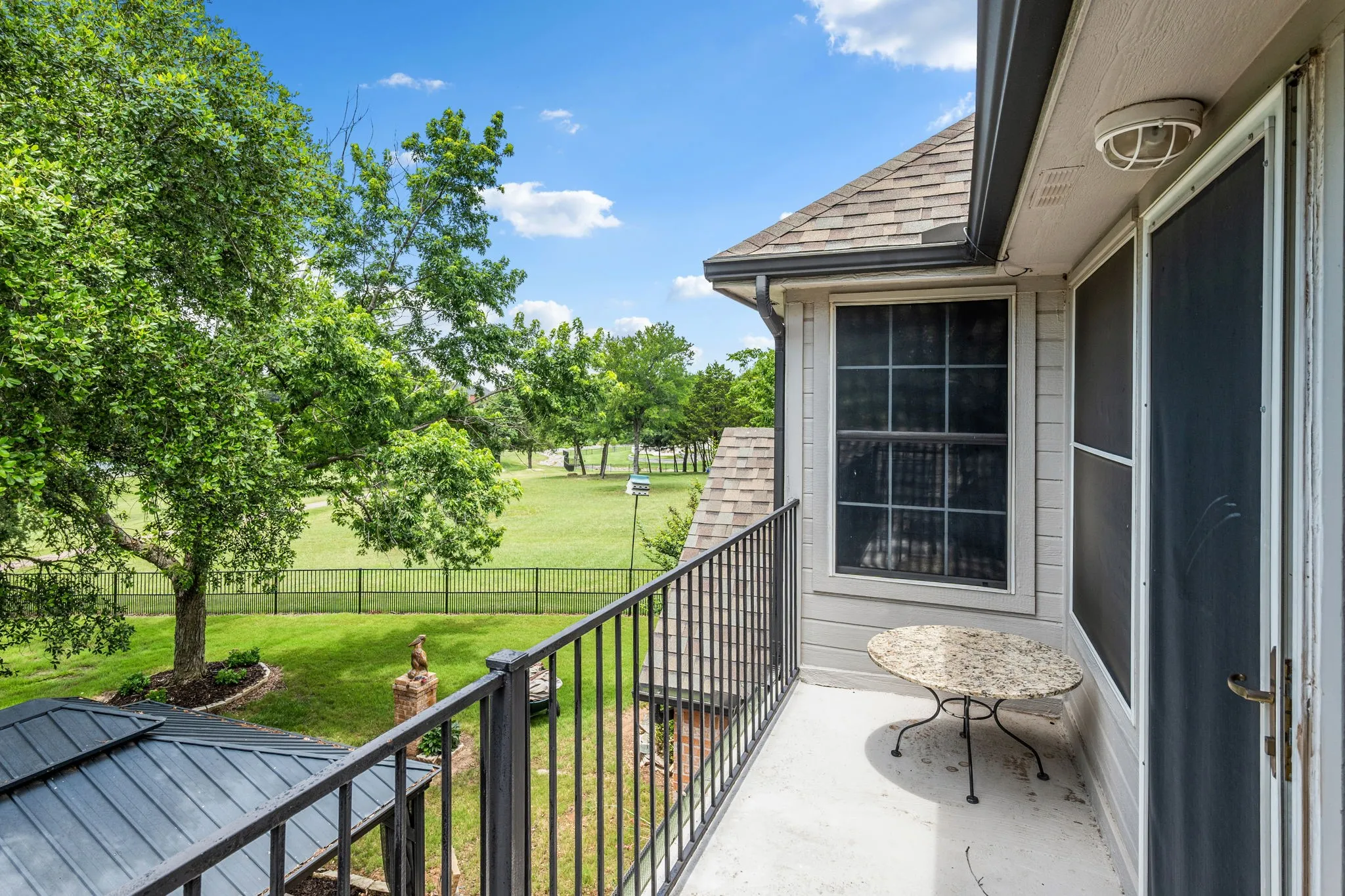 Balcony featuring a black wrought iron railing and a concrete surface