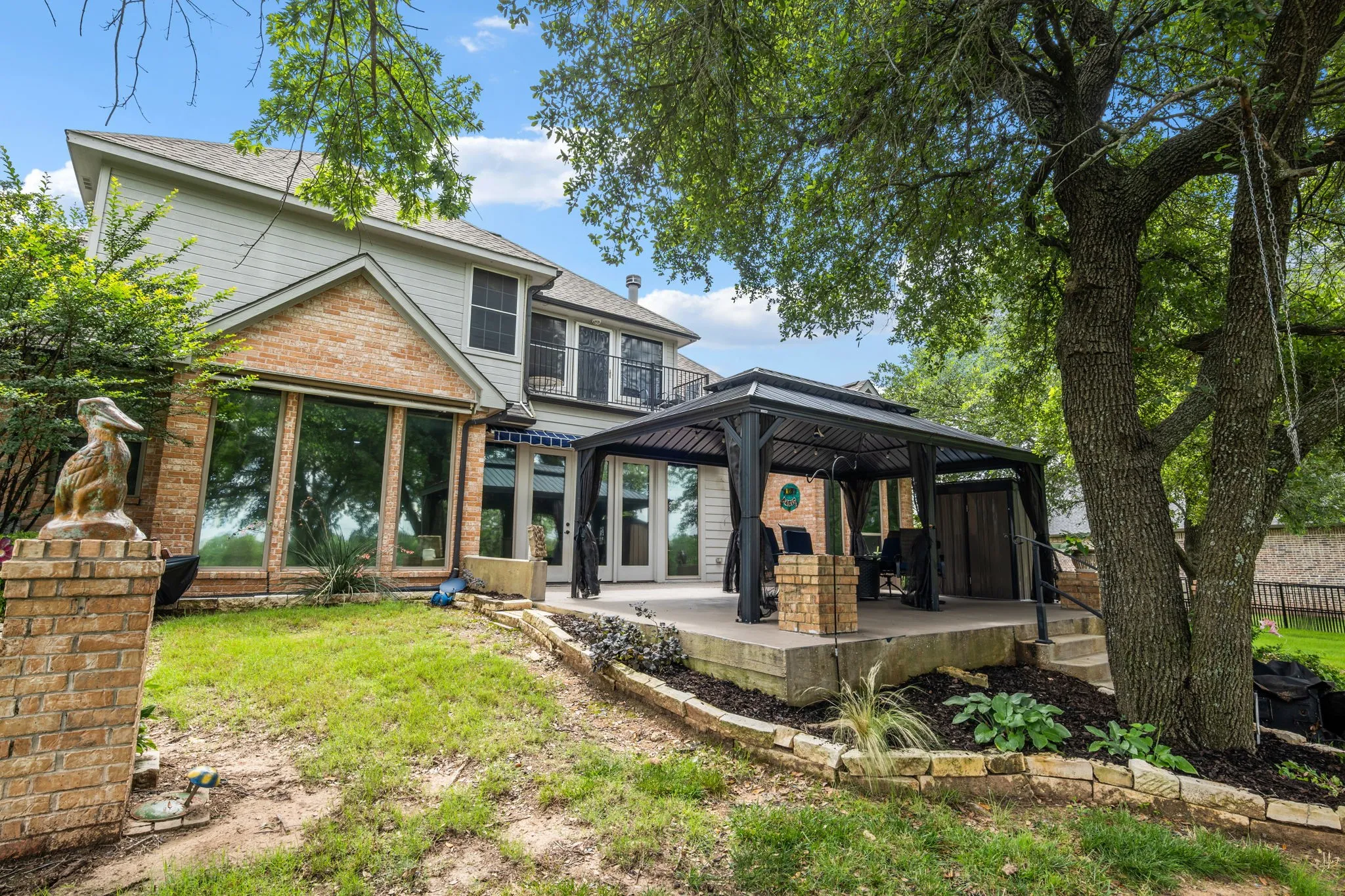 Rear facade featuring a prominent brick and siding exterior