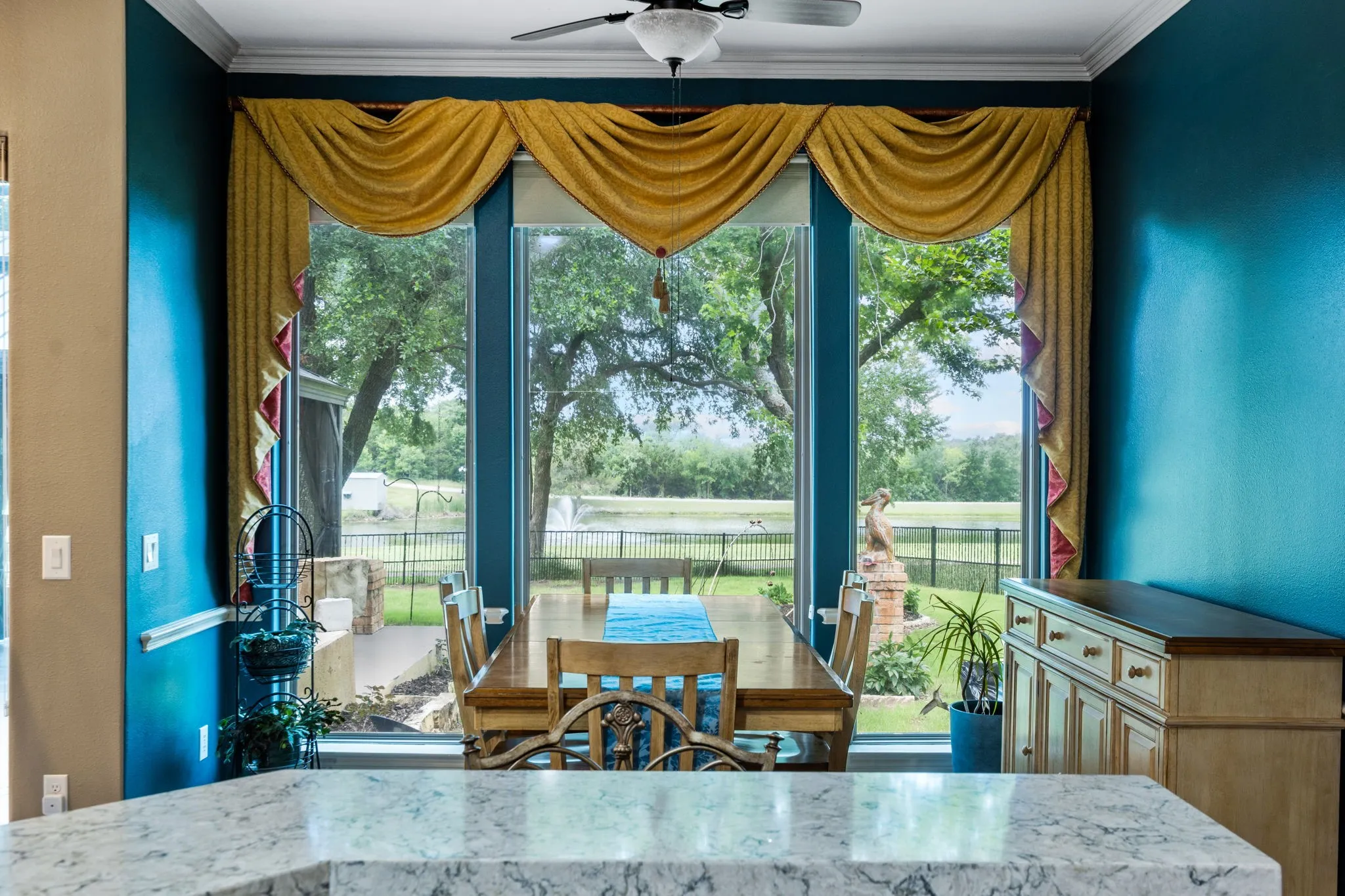 Dining area featuring expansive floor-to-ceiling windows, a ceiling fan, and crown molding