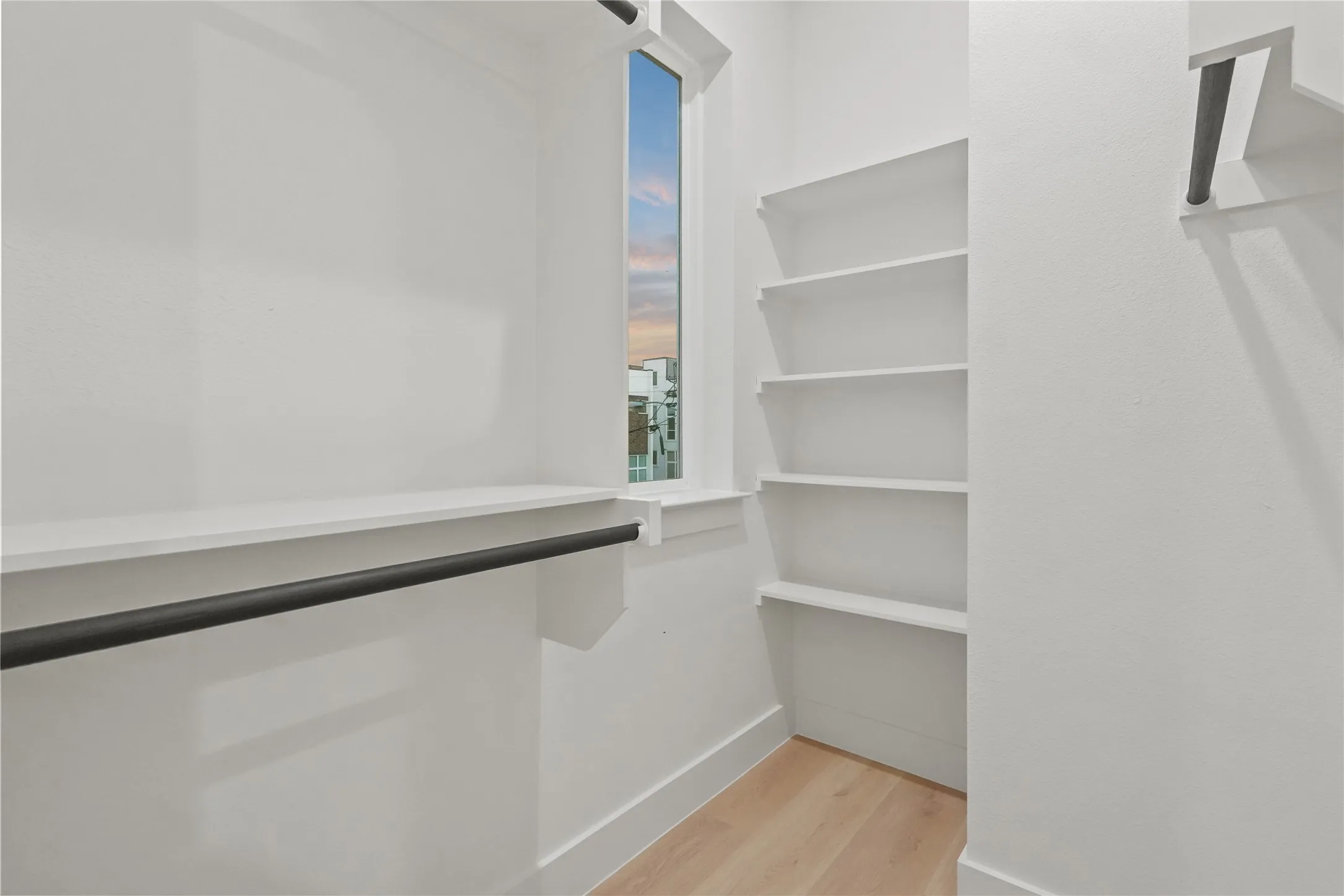Walk in closet with light wood-type flooring