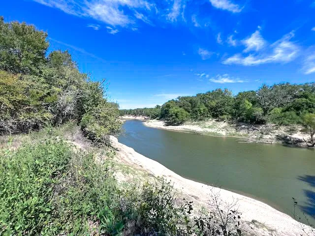 Peaceful Trinity River frontage creates a stunning backdrop for a custom barndominium or family compound.