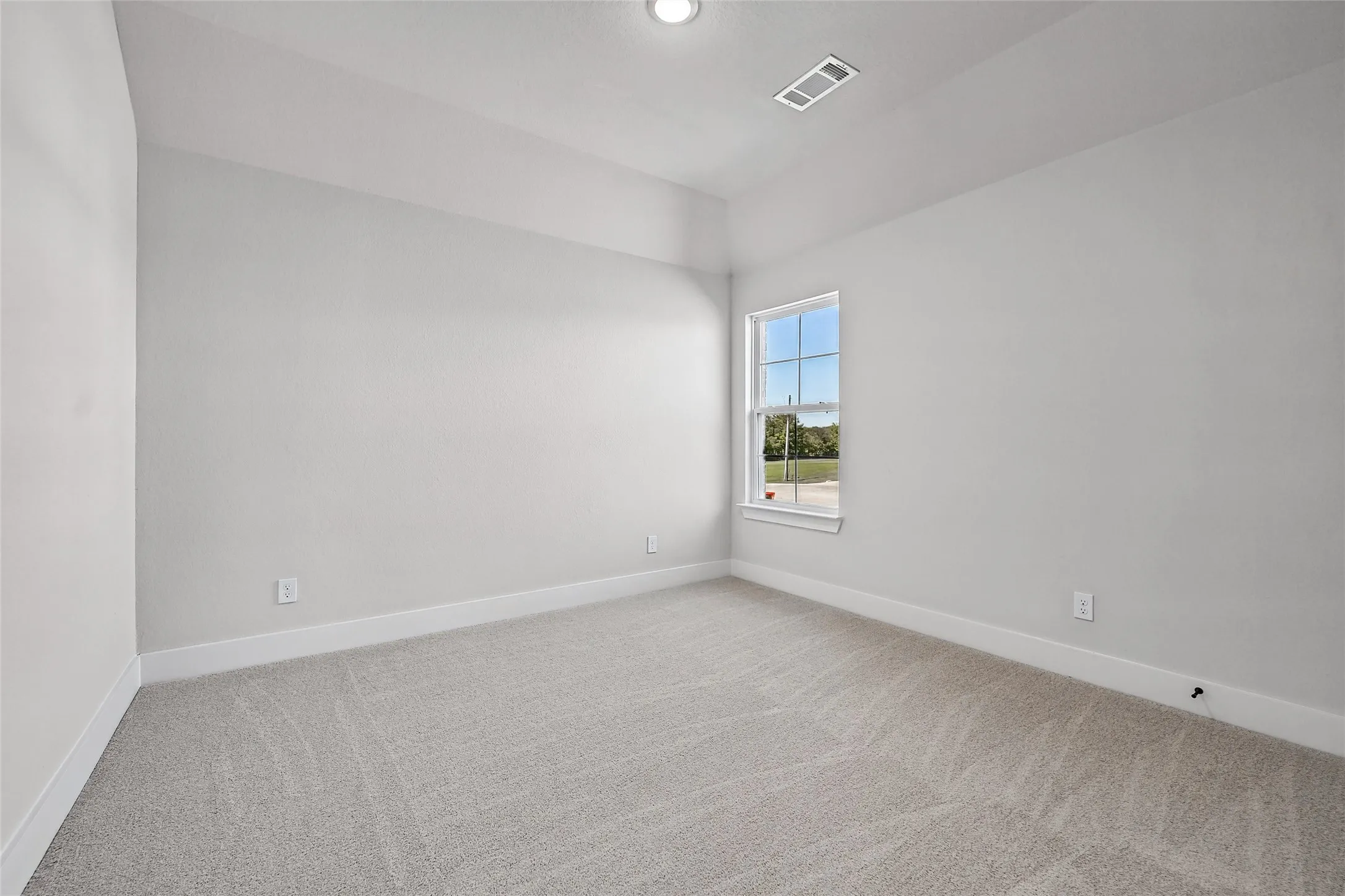 Recessed ceiling light, single window, light-toned carpeting, white trim, and light gray wall paint