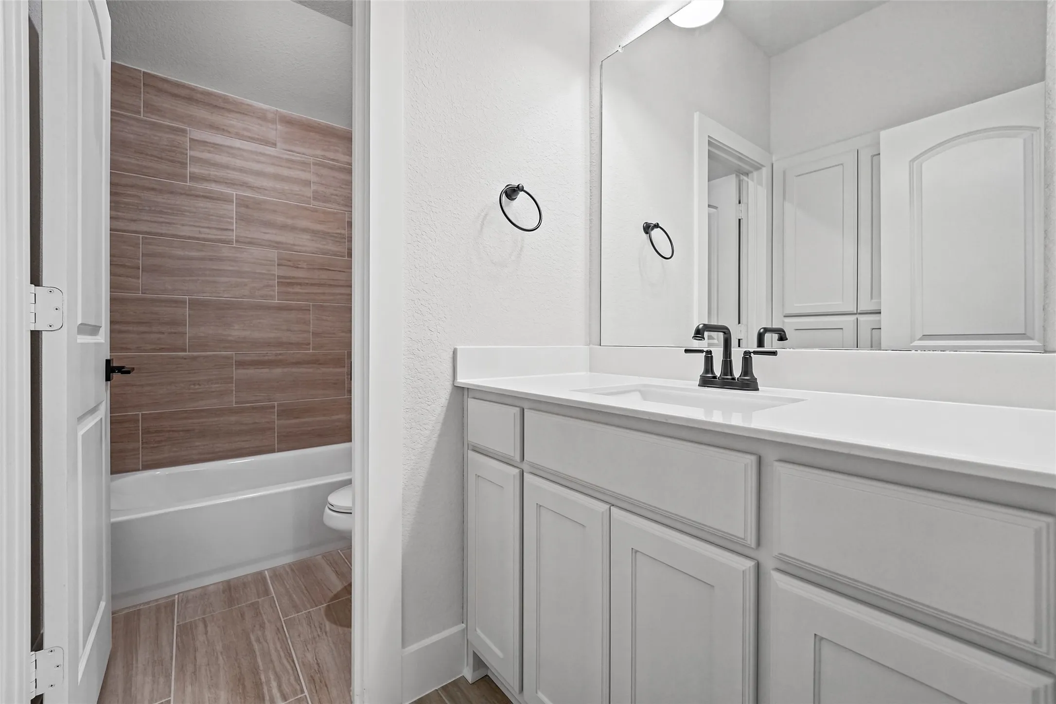 White shaker-style vanity with a white countertop and integrated sink