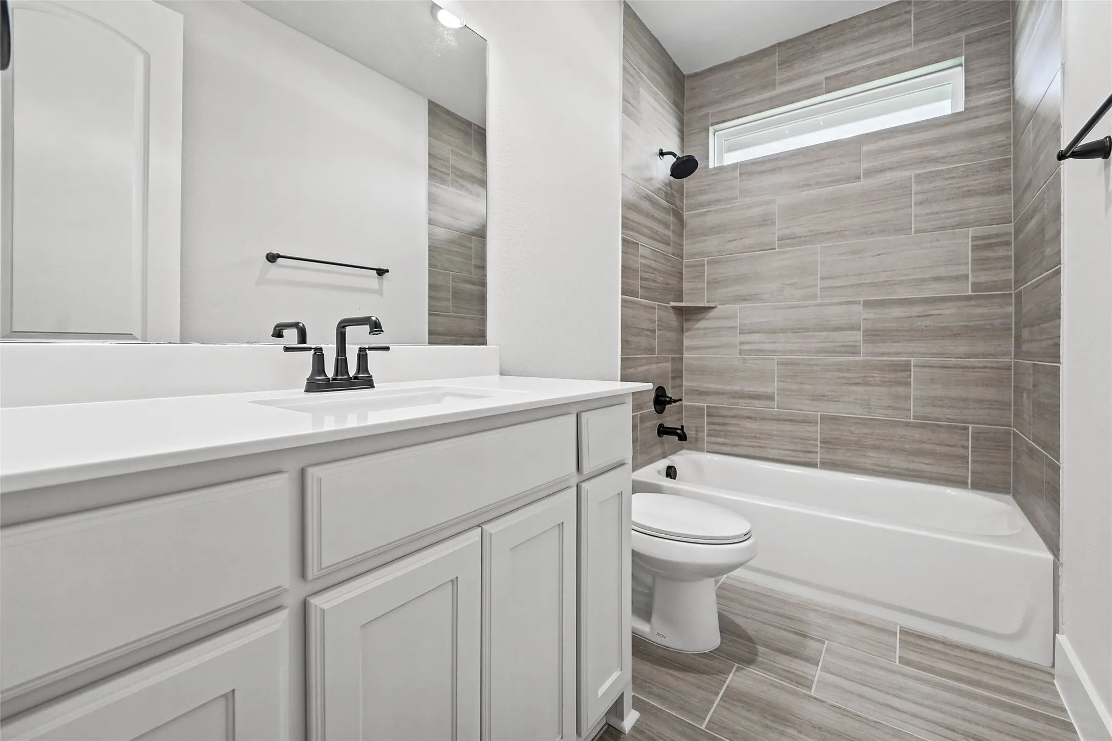 White vanity with an integrated sink, matte black faucet, and white countertop