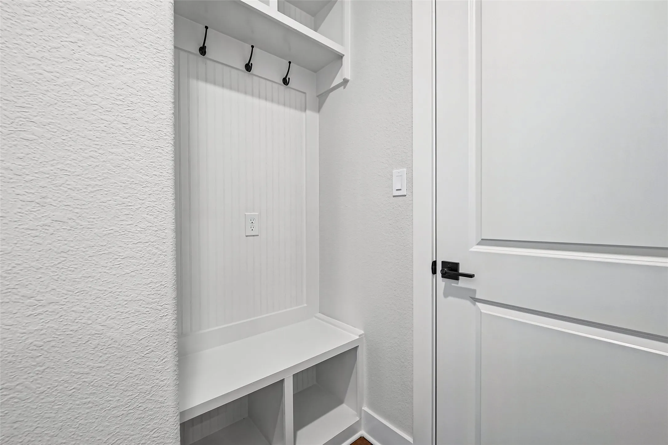 Built-in storage bench with overhead shelving and coat hooks