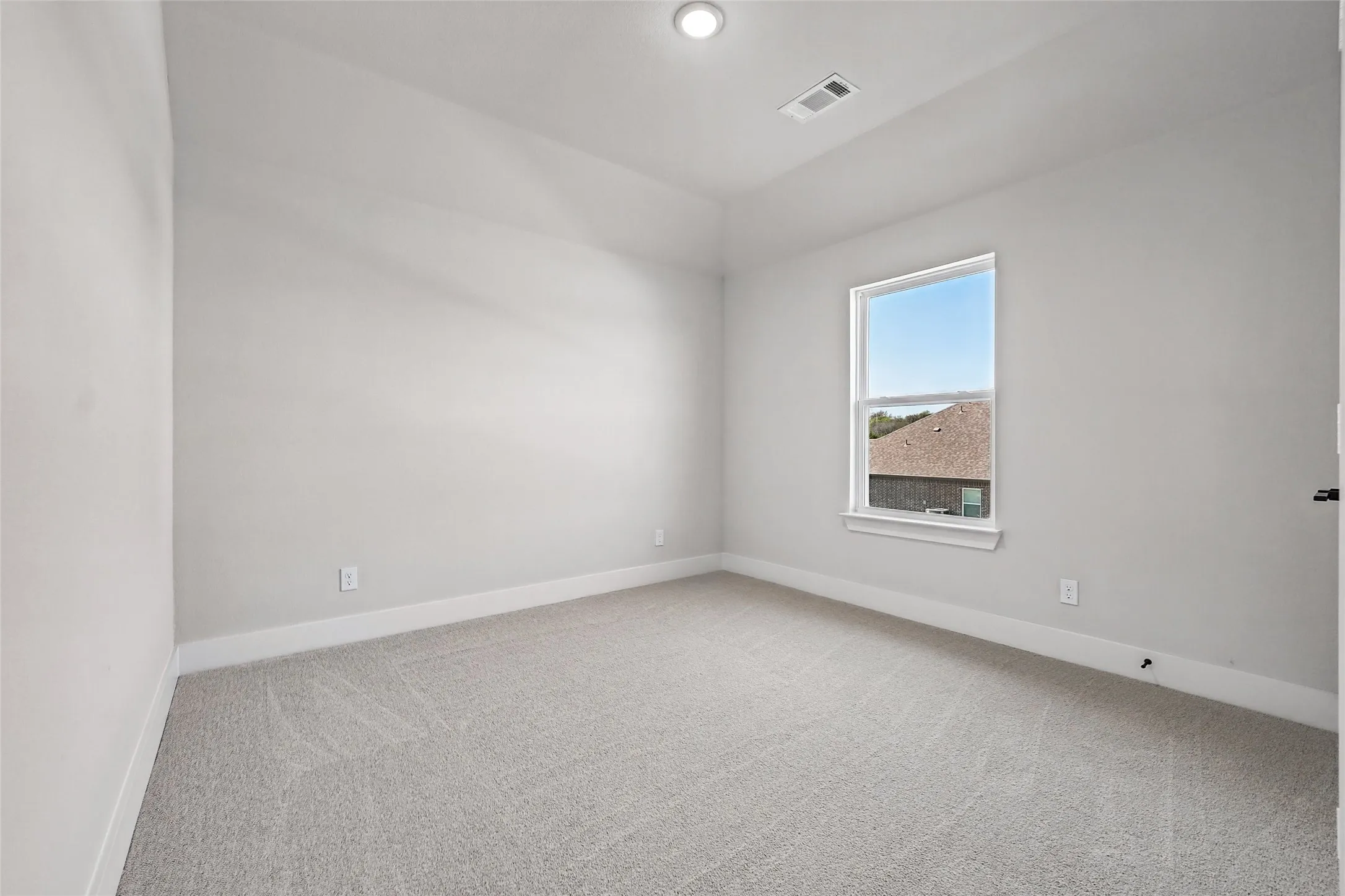 Recessed lighting, light gray carpeting, white trim, and a single window