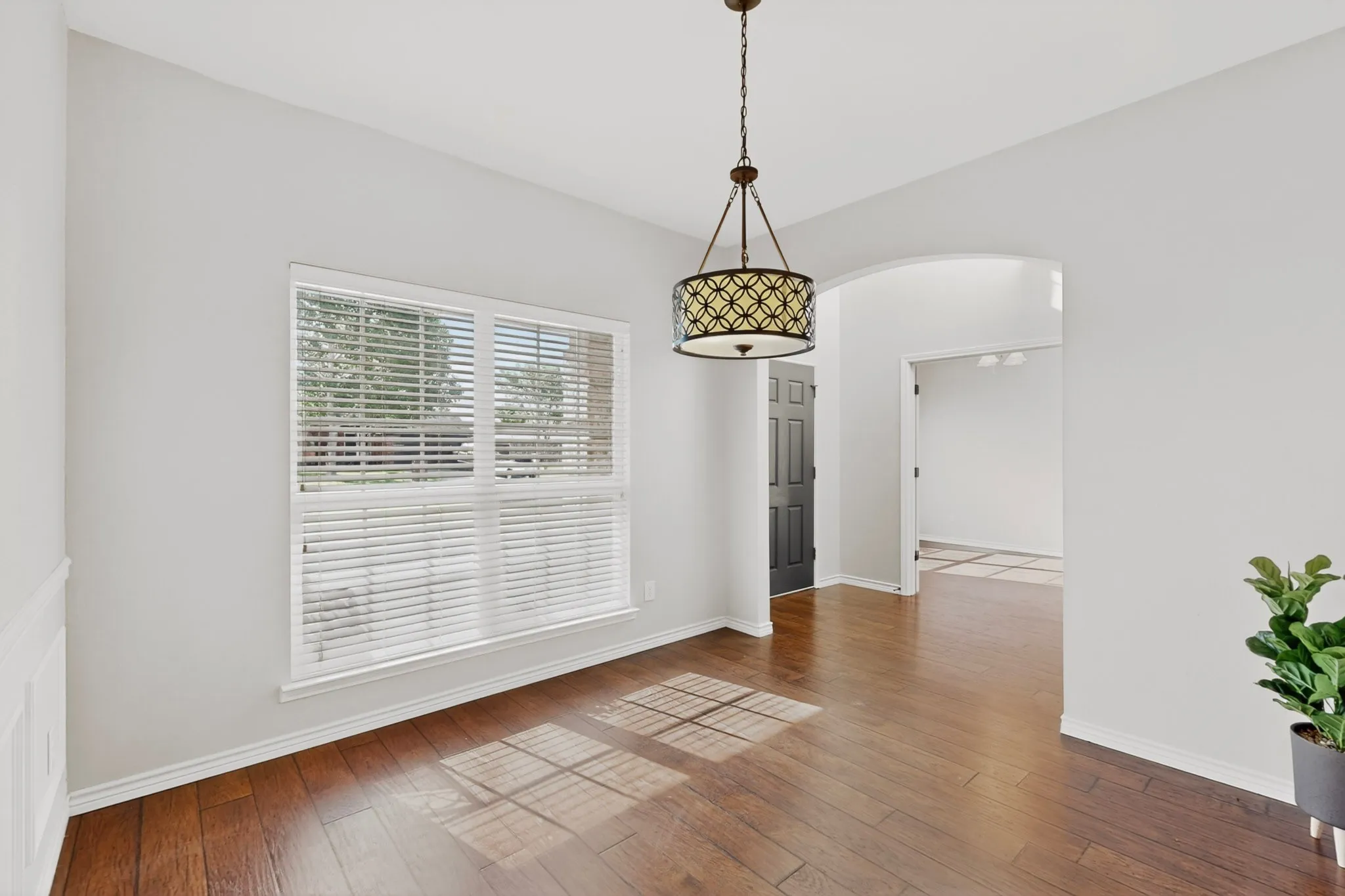 The formal dining room includes updated lighting and hard floors.