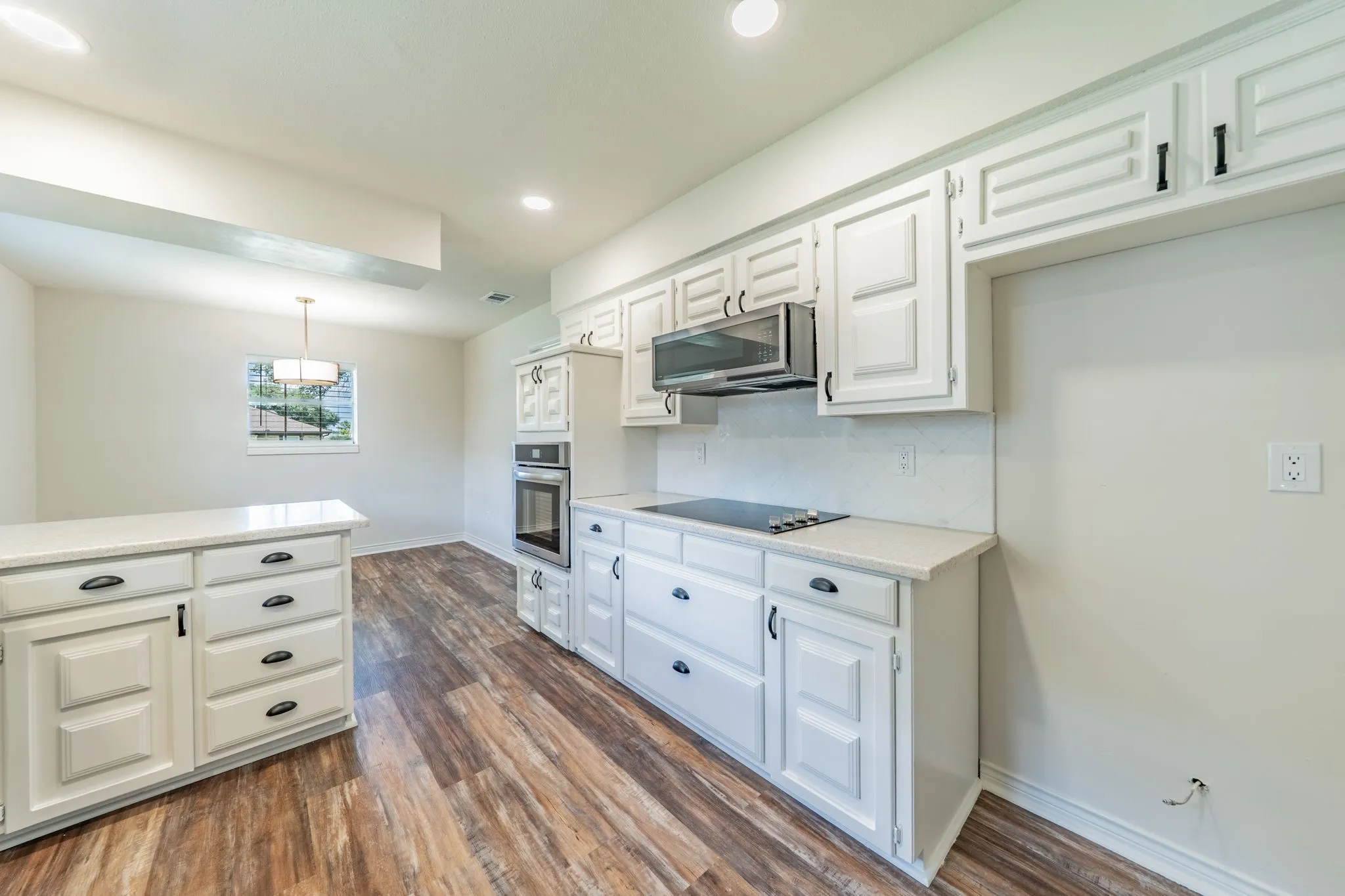 Kitchen featuring white cabinetry, wood-finish flooring, recessed lighting, and a built-in oven with an integrated cooktop