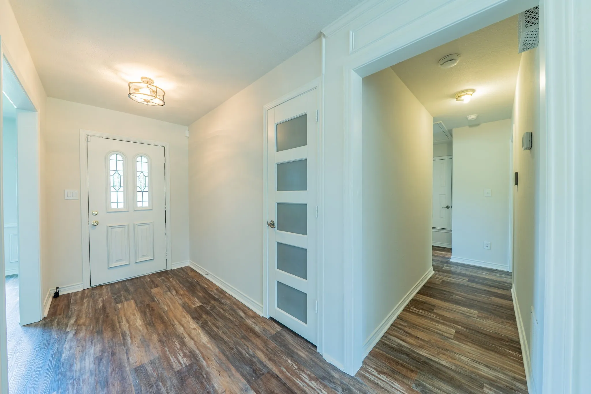 Entryway featuring wood-finish flooring and a decorative flush-mount ceiling fixture