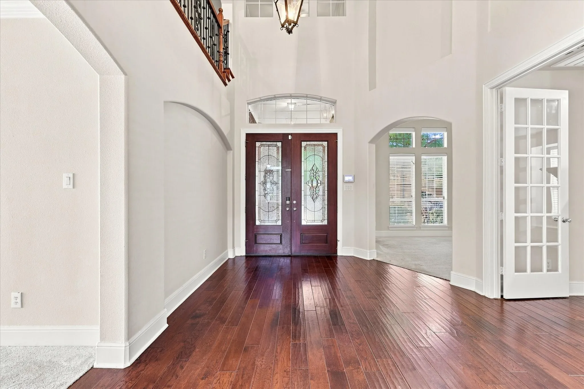 Two-story foyer with rich wood-finish flooring