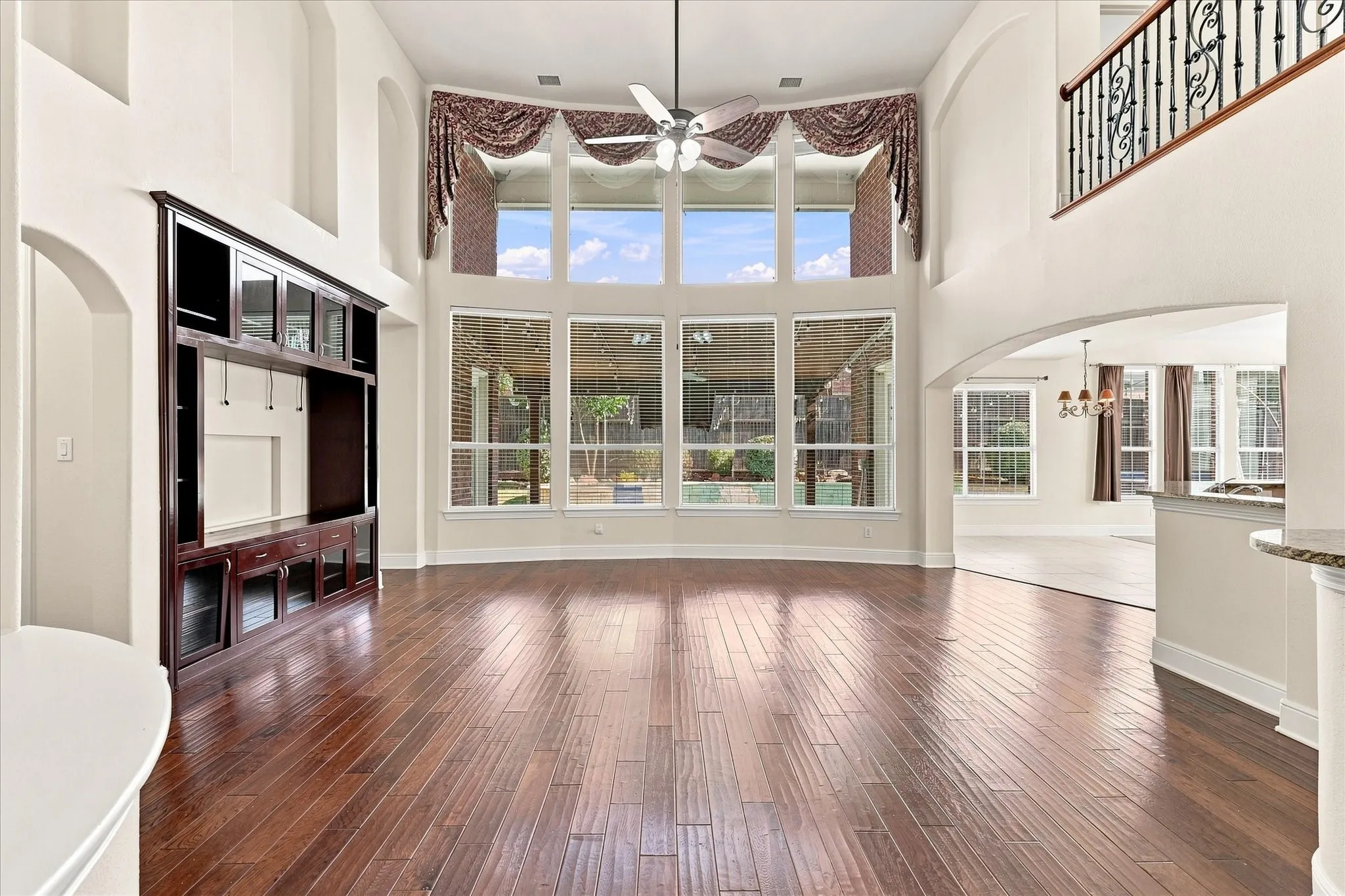 Soaring two-story great room with expansive multi-pane windows flooding the space with natural light