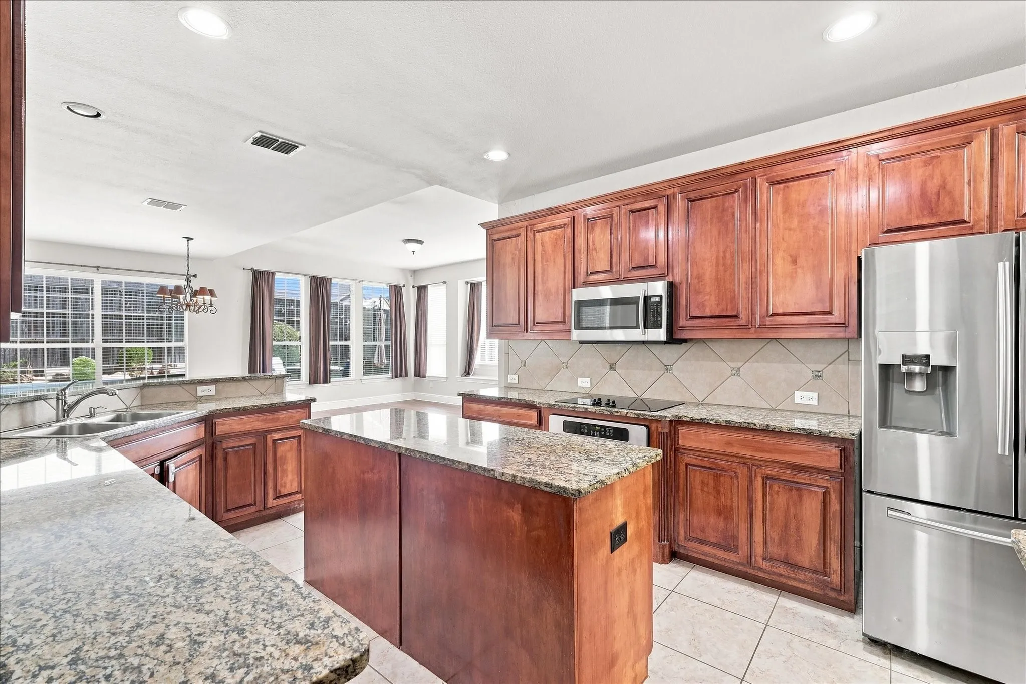 Kitchen featuring a center island, extensive cabinetry, tile flooring, and stainless steel appliances