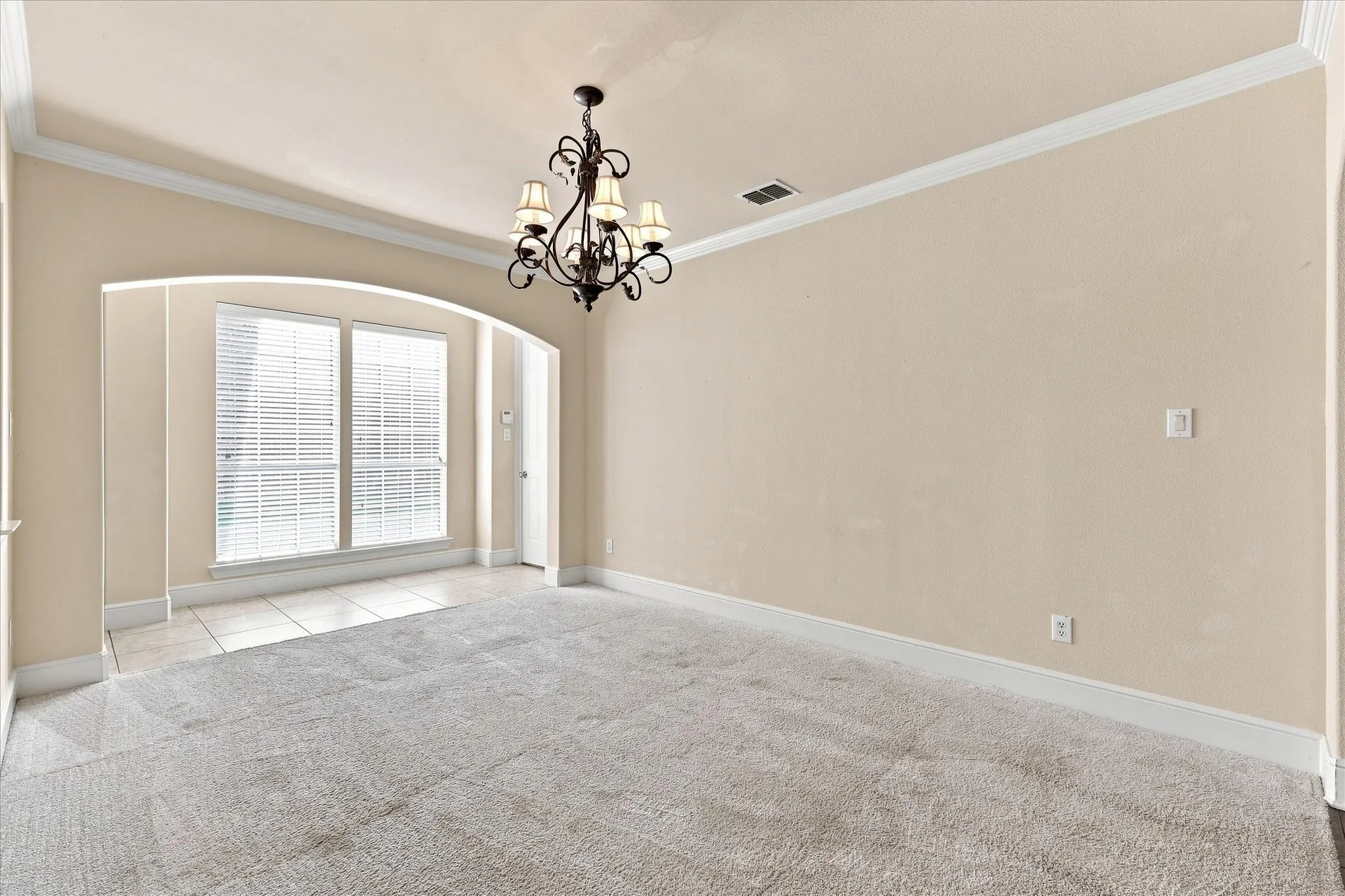 Recessed arched opening framing dual windows with plantation shutters