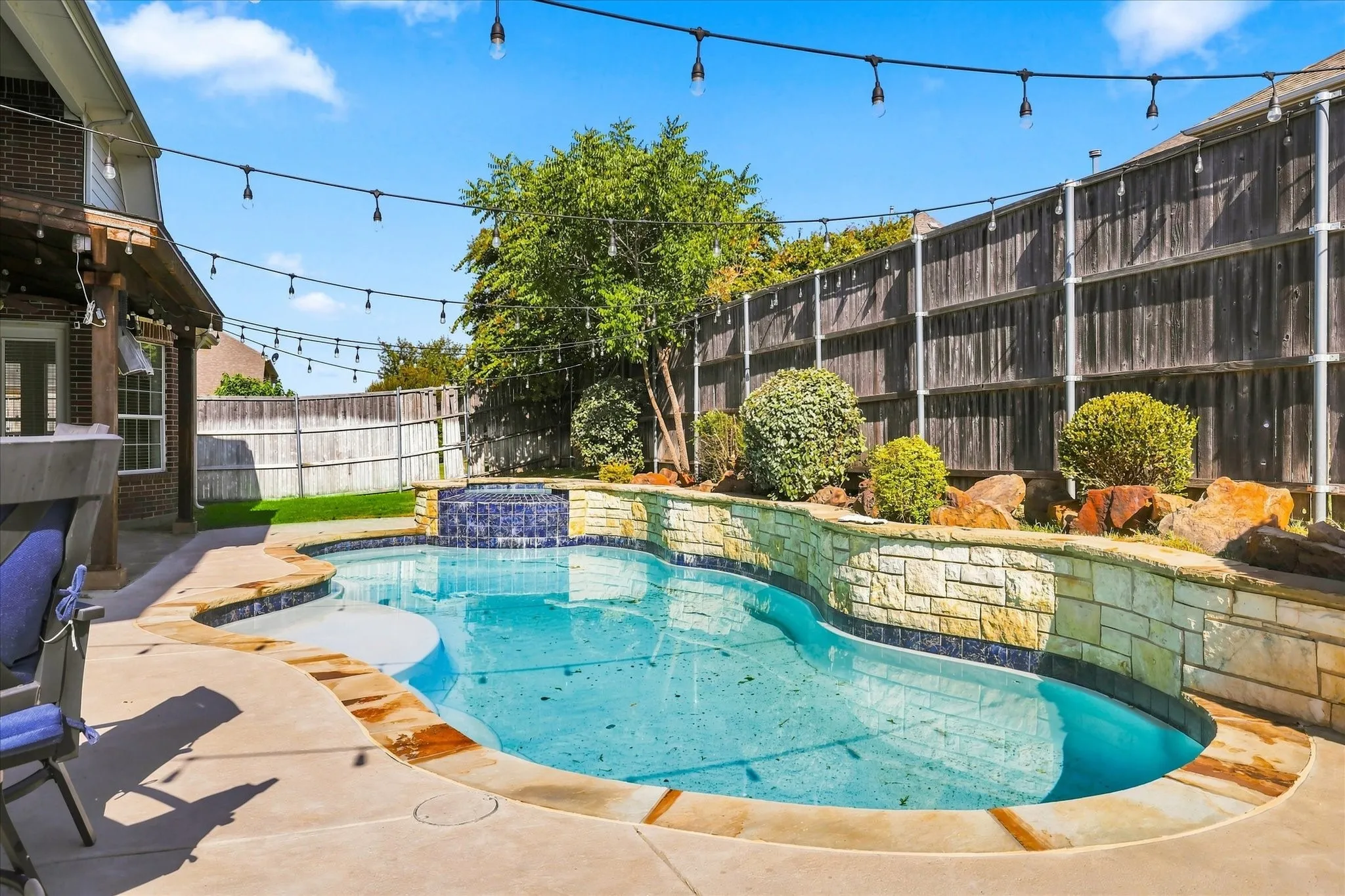 Swimming pool with stone surround and waterfall feature