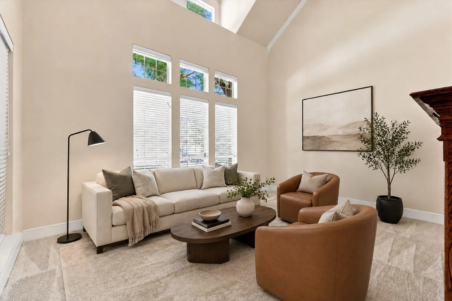 Virtually Staged High vaulted ceilings, multiple transom windows, light-toned carpeting, and a wood mantelpiece